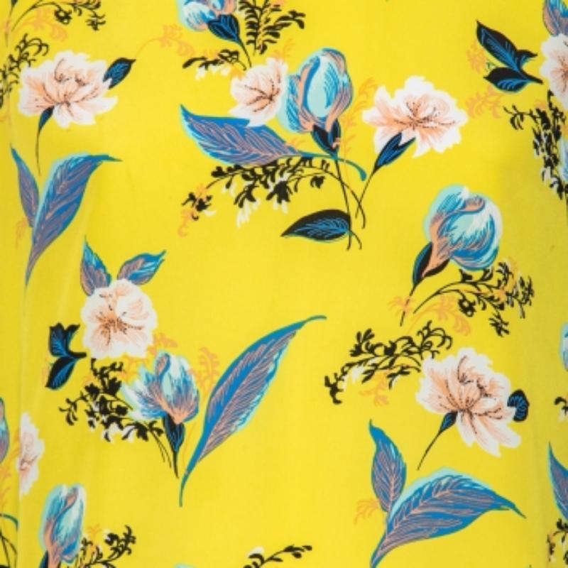 Dieses hübsche Oberteil von Diane von Furstenberg mit floralem Muster steht für Eleganz und Gelassenheit im Sommer. Es wurde aus gelb-blauem, mit Blumen bedrucktem Seidenstoff geschneidert und ist ärmellos.
