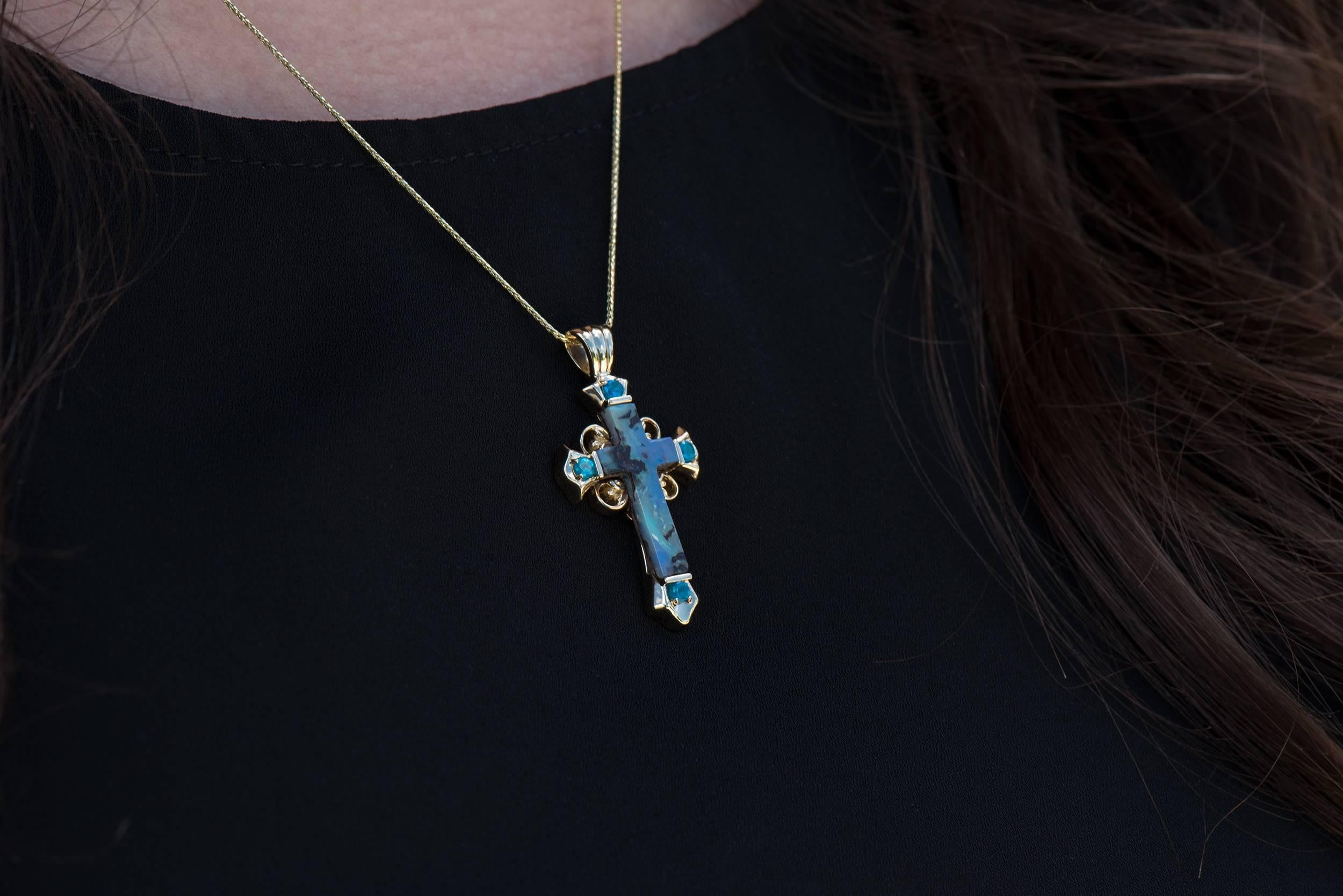This pendant is a Dianna Rae Original featuring a genuine Australian boulder opal.  The opal has amazing rivers of blue, green and brown flowing through it.  The accents gems are genuine apatite with an intense blue color.  The cross is 14K yellow