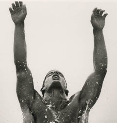 Kenny che emerge (giovane uomo nudo che emerge dal mare con le braccia alzate verso il cielo)