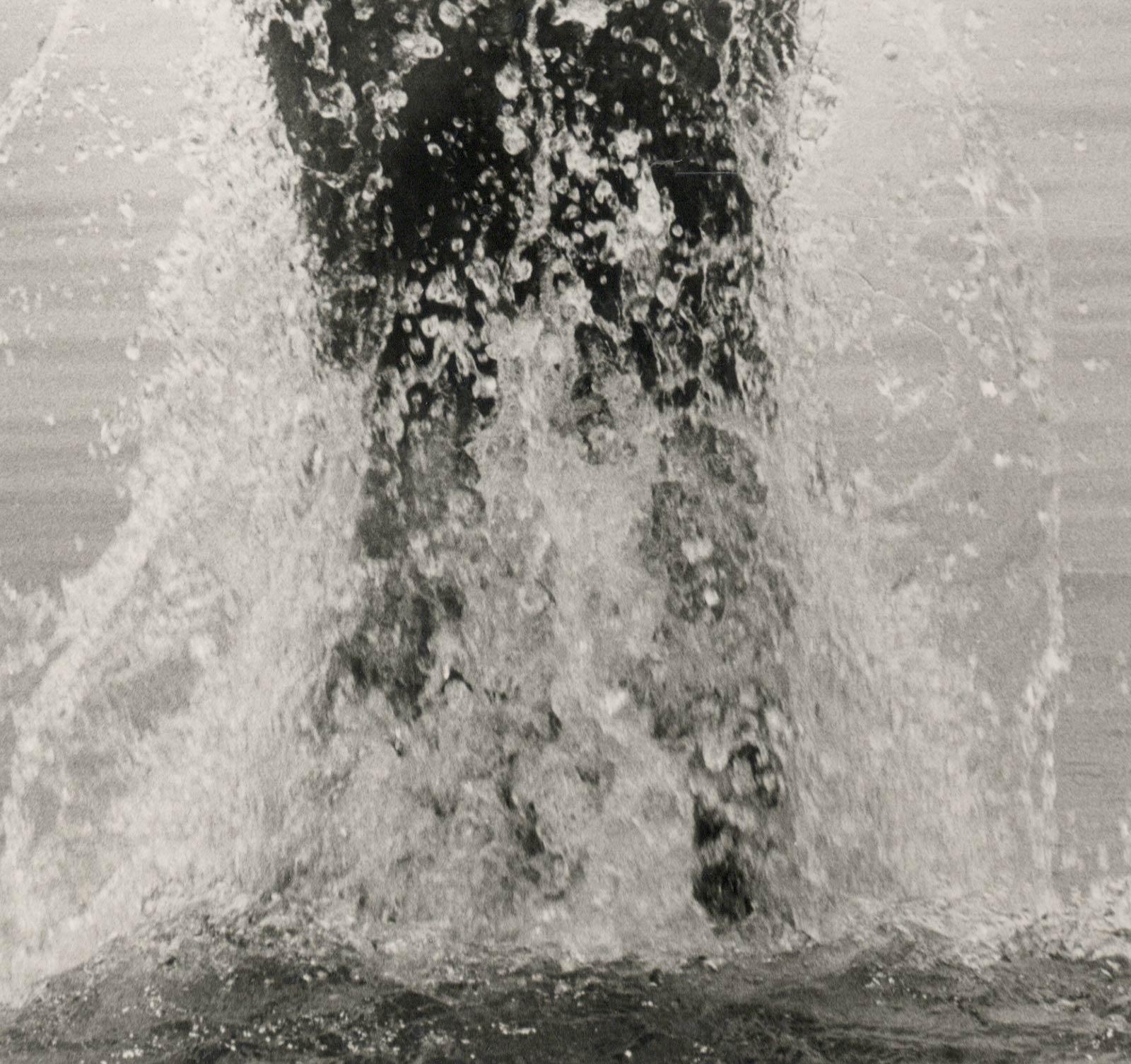 Kenny Surfacing (jeune homme nu sautant hors de la mer les bras levés vers le ciel) - Réalisme américain Photograph par Dianora Niccolini