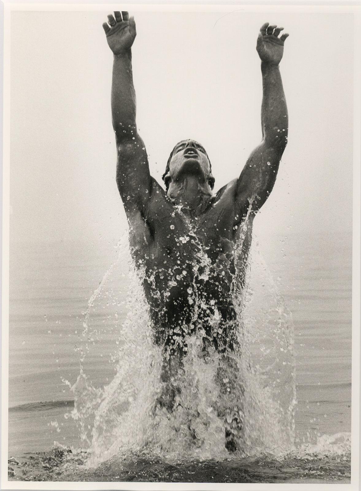 Dans cette photographie vintage à la gélatine argentique, Dianora Niccolini crée un portrait sensuel d'un jeune homme nu émergeant des flots, les bras tendus.  La photo suggère un esprit de renouveau, un éveil.  Niccolini s'est inspirée d'un poème