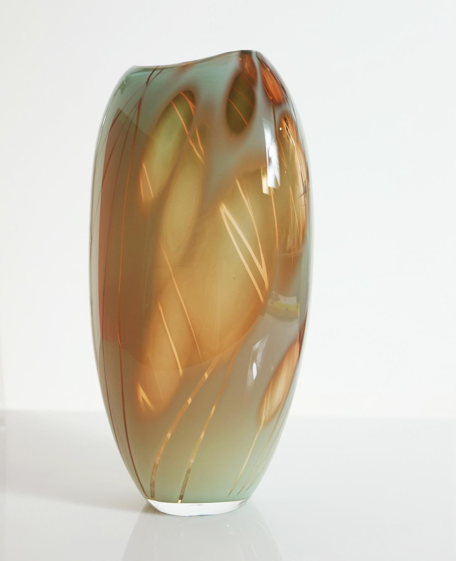 Le récipient en verre Dianthus s'inspire de la plante en utilisant du verre céladen et abricot.
Il a été créé à l'aide de la technique suédoise classique du graal, où le motif est découpé à la main sur un tour à l'aide de roues de gravure au