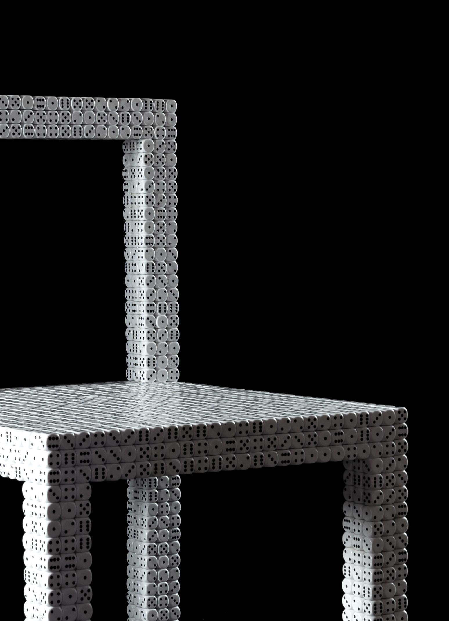 Die 'Dice'-Stühle sind reine Poesie, sie stehen für das Spiel und die Freiheit der Schöpfung. Die Collection'S besteht aus zwei einzigartigen Stühlen, die aus einer Metallrohrstruktur mit einer Bespannung aus 3.527 Würfeln mit den Maßen 16 x 16 mm