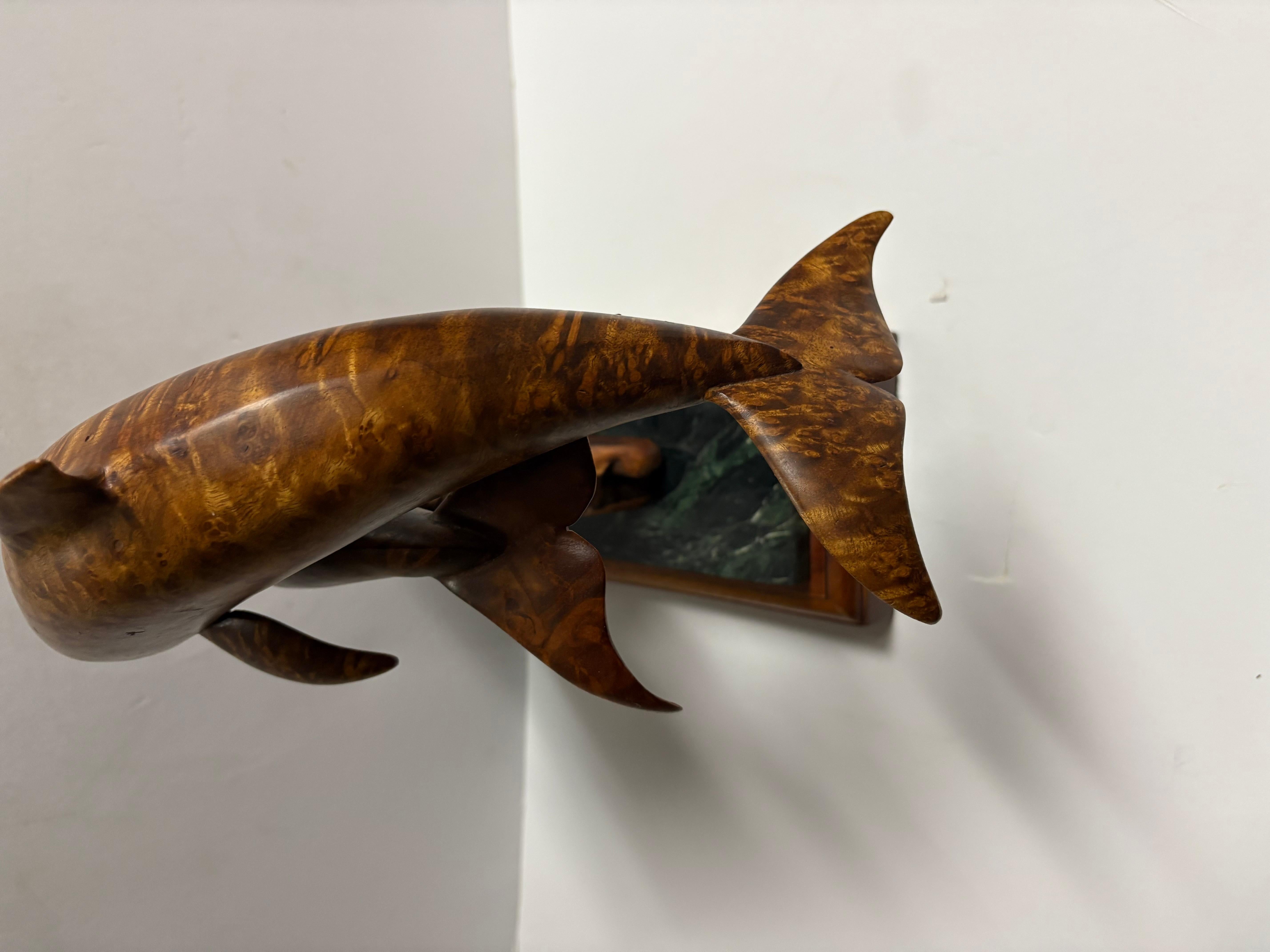 Scultura in legno scolpito di delfini. firmata, con targhetta alla base con scritto 