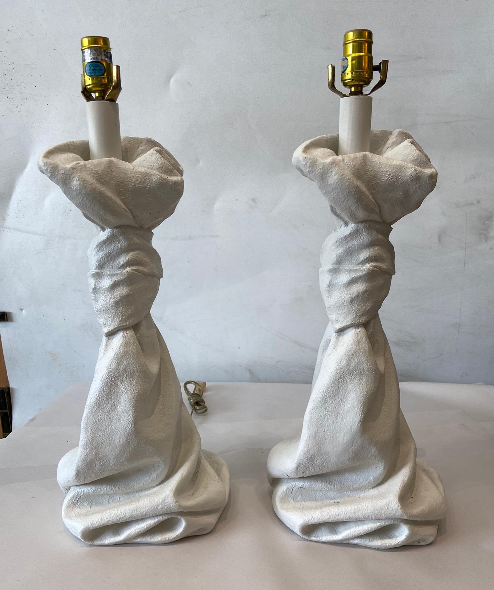 Pair of Jonathan Dickinson style plaster table lamps. Knot at the top twisted stem with a linen fold base.