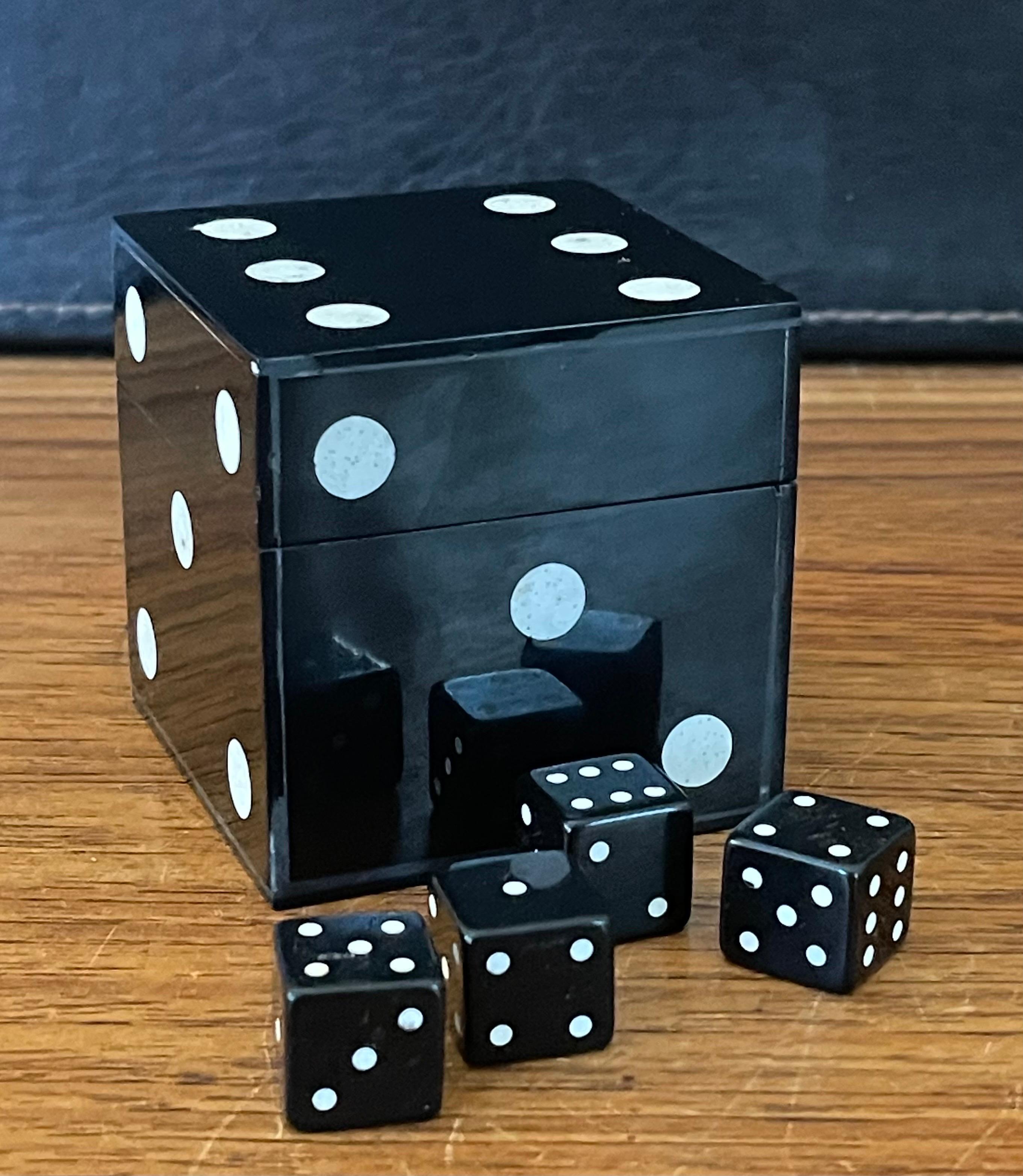 A cool die /dice paperweight / trinket box with four small dice, circa 1990s. The piece is a lidded wood box covered in black laminate at has a lid and two pair of black dice inside. The box measures 2.75