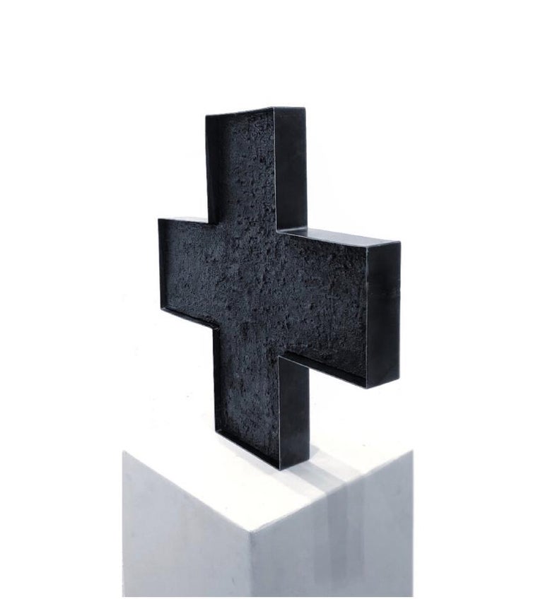 Textured minimalistic abstract black cross sculpture.
"Through this body of work I found the opportunity to open a dialogue about identity, rediscovering it through the stories embodied in each of the artworks. These stories are memories that speak