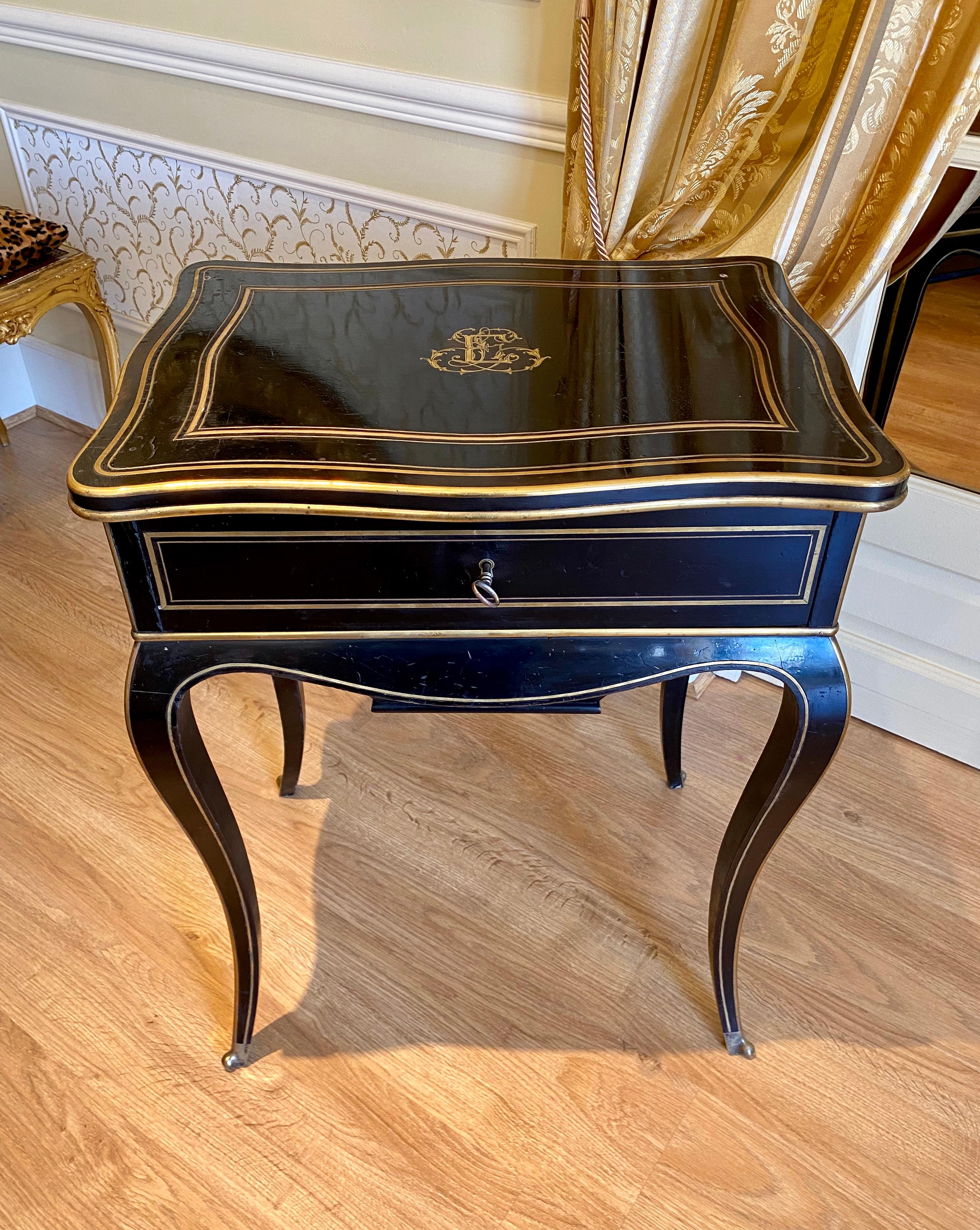 Lovely table with works or dressing table in ebony Louis XV - Napoleon III style. It is decorated with gilded and chiselled bronzes, signed on the interior lock 