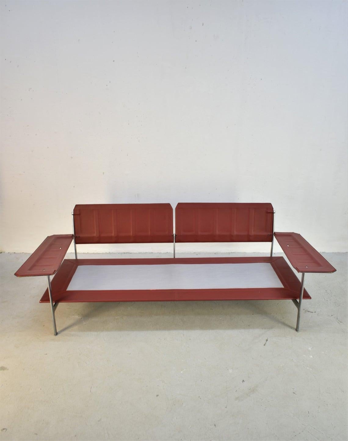 Divano Diesis progettato da Antonio Citterio e Paolo Nava per B&B Italia nel 1979.

Questo divano a due posti è rivestito con tessuto rosso originale e ha cuscini sciolti in piuma d'oca (6). Struttura in alluminio lucido con braccioli e schienale