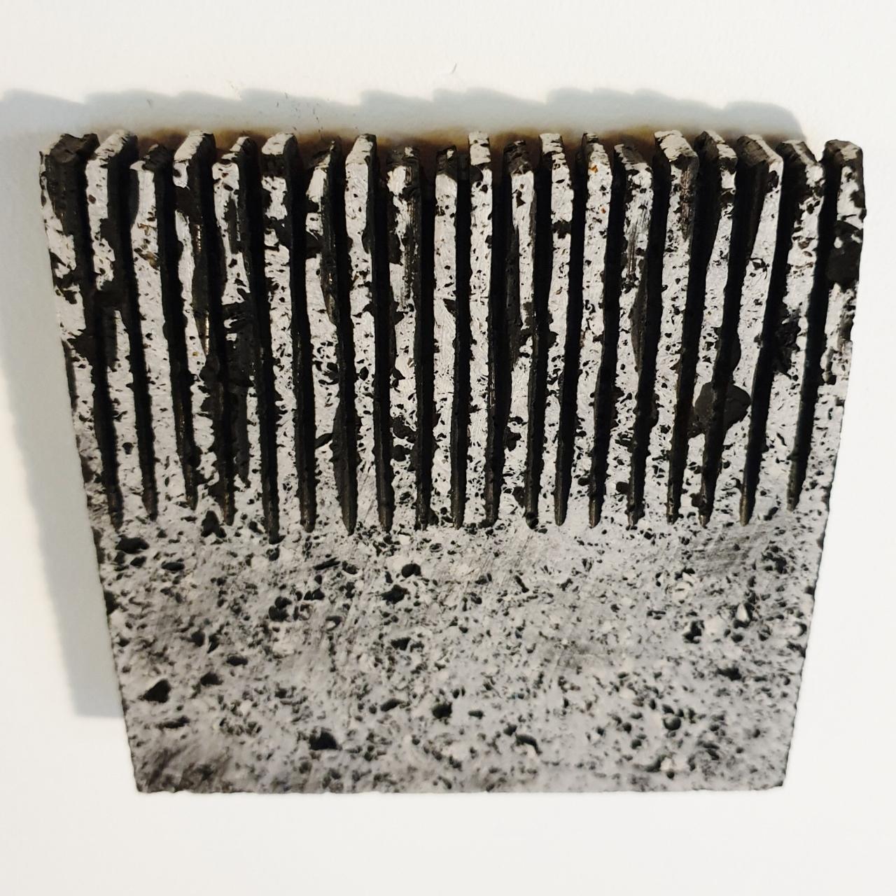 o.T. (Bk15Hf) is a unique small size contemporary modern wall sculpture painting relief by German artist Dieter Kränzlein. The relief is made from limestone and the carved pattern is finished with a thin layer of black ink that has penetrated into