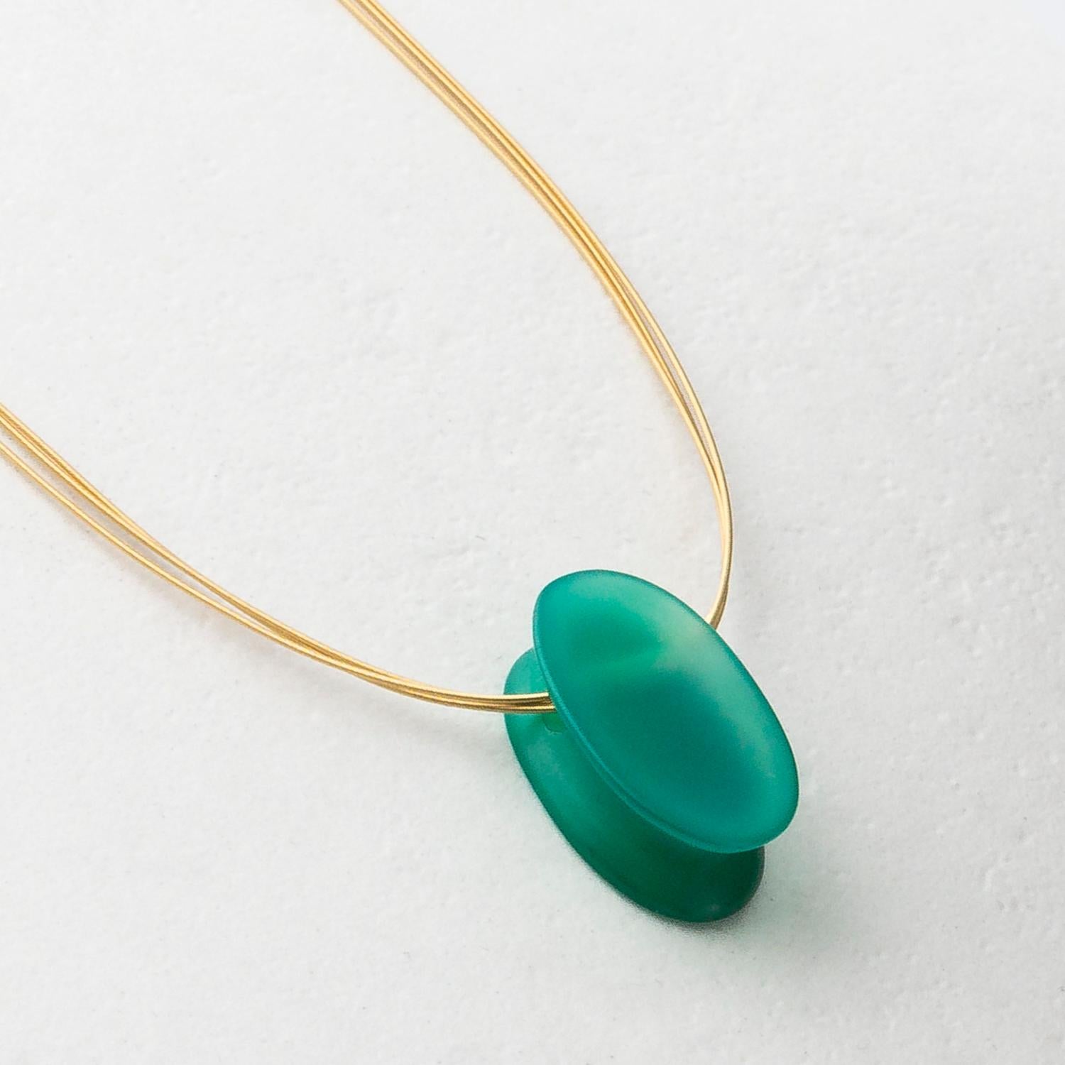 Handcarved by Dieter Lorenz, one of the top names in contemporary gem-carving, this green Agate pendant is carved into a lozenge shape with a narrow interior and hung on an 18 Karat Yellow Gold multi strand necklace.

Made by hand in our family run
