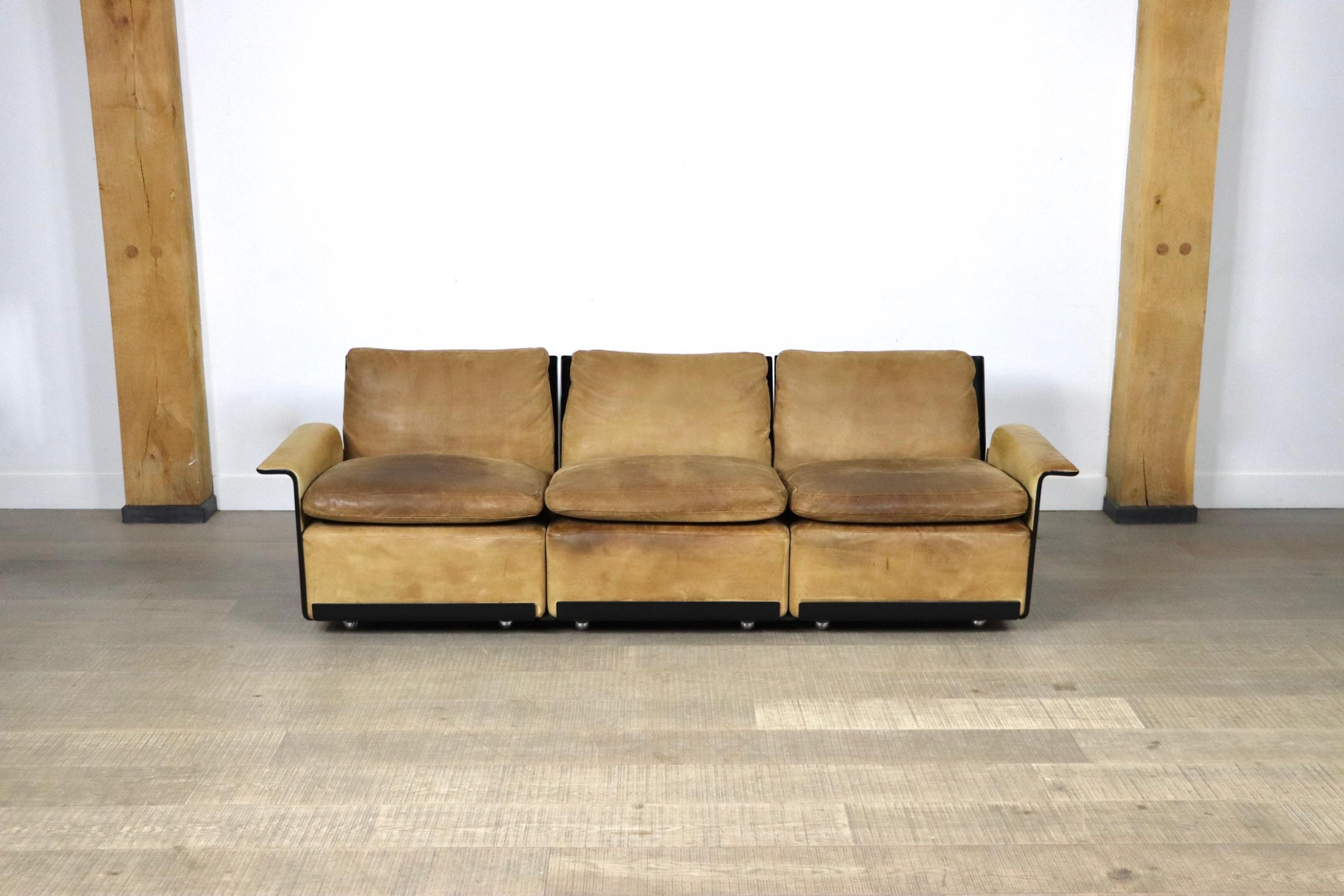 Ikonisches Sofa von Dieter Rams für Vitsoe. Die schwarze Außenhülle besteht aus einer heißgepressten Formmasse, die ähnlich wie Glasfaser ist, aber stärker als diese. Ursprünglich mit hochwertigem, weichem Cognac-Leder gepolstert, das Generationen