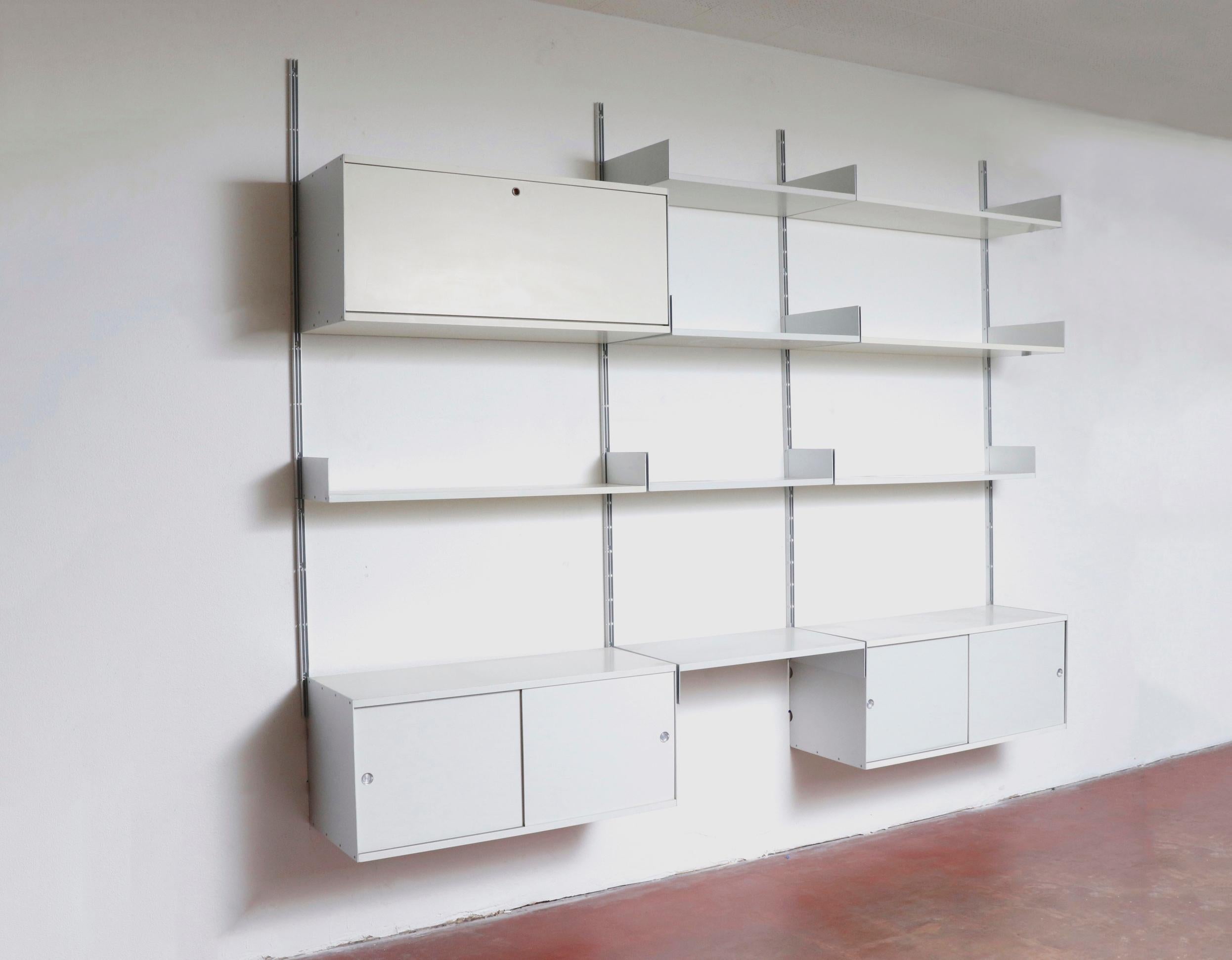 Rare 3 section Dieter Rams industrial shelving unit on aluminum risers with storage cabinets and 8 assorted shelves. Two cabinets with sliding doors, one with a drop-down door, and missing the lock. In original condition with visible wear. Wear is