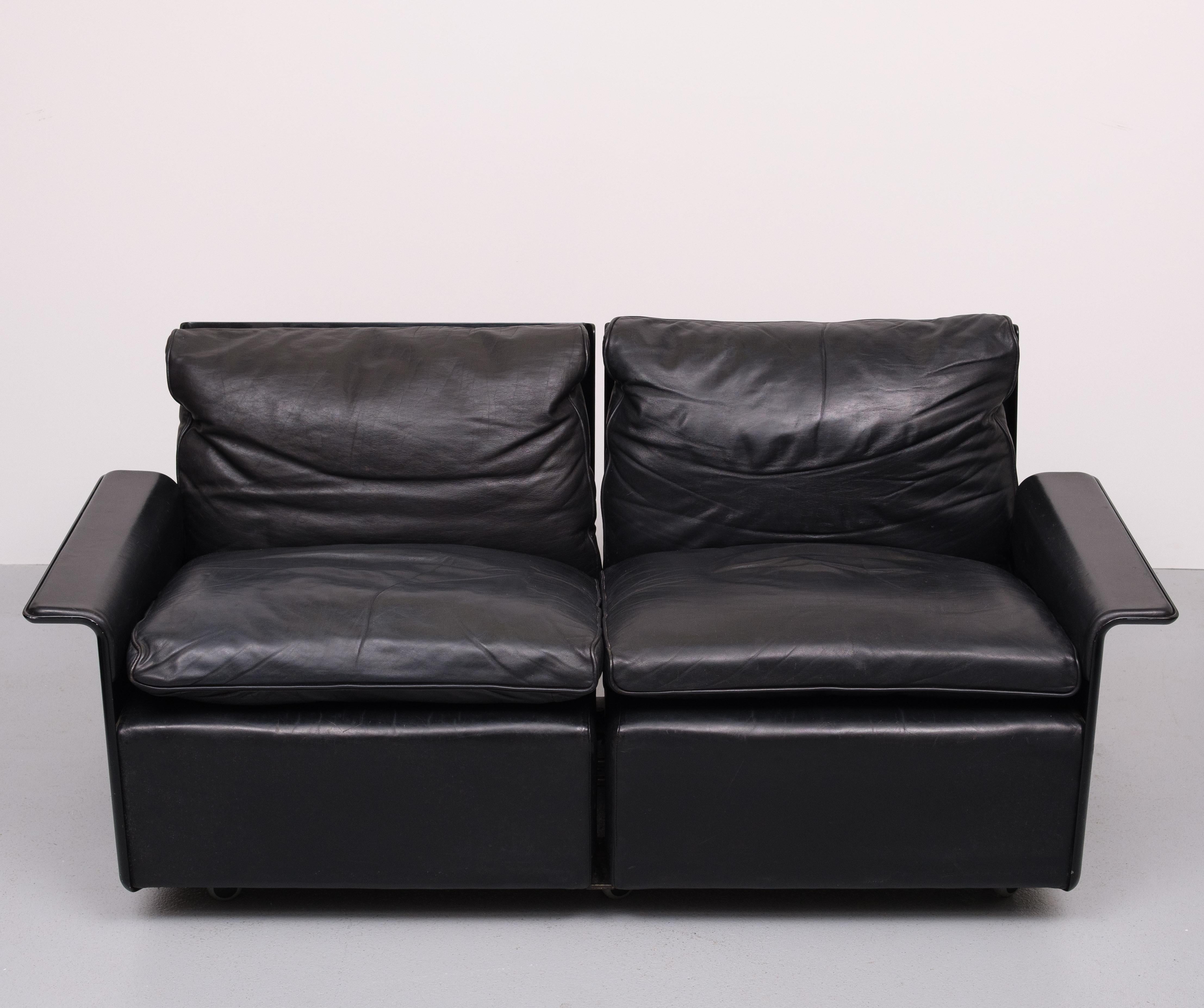 This beathiful low back two seat Sofa  from the 620 range was designed by Dieter Rams. for Vitsoe in the 1960s It has a black shell made of fiberglass reinforced plastic. It is covered with black full-grain aniline-dyed leather. On brand new wheels