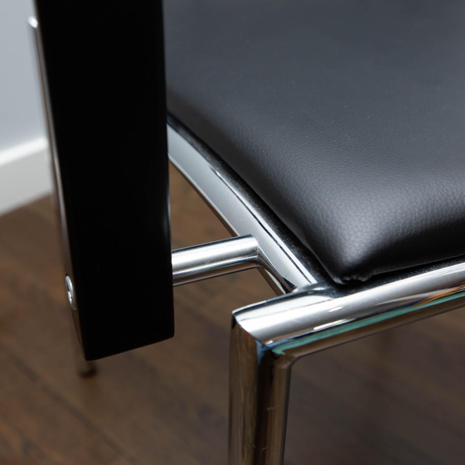 Designed by Bruno Rey and Charles Polin, this modern armchair features chrome frame with a black leather seat and back and leather-wrapped arms over matte black sculptural wooden arms. New old stock. No longer in production.