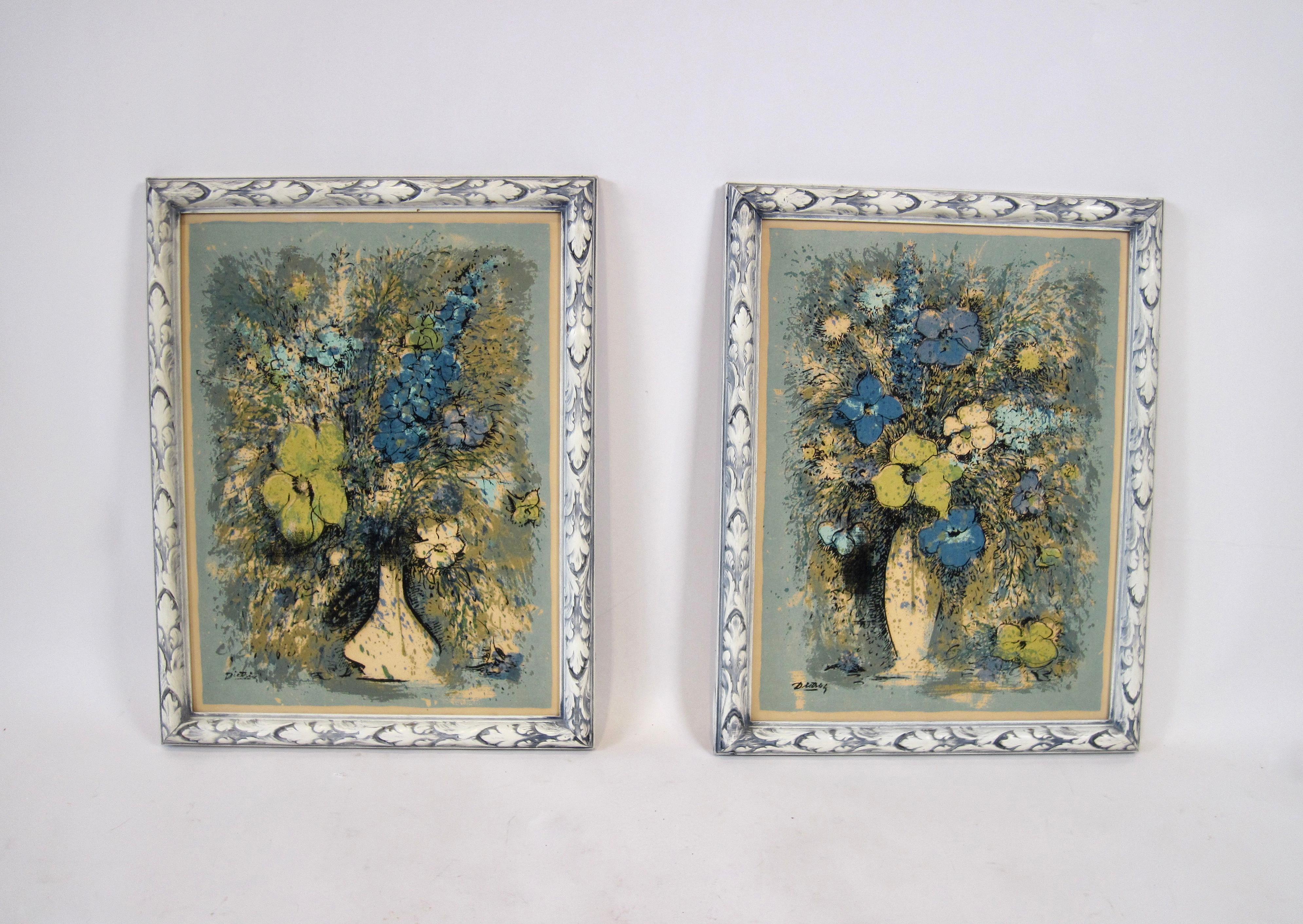 A pair of floral serigraph prints by Swedish born artist, Dietrich Grunewald. Bouquets of flowers in blues, cornflower, yellow, olive, and cream are expressively punctuated and outlined in black.  Beautifully complimentary carved wood frames are