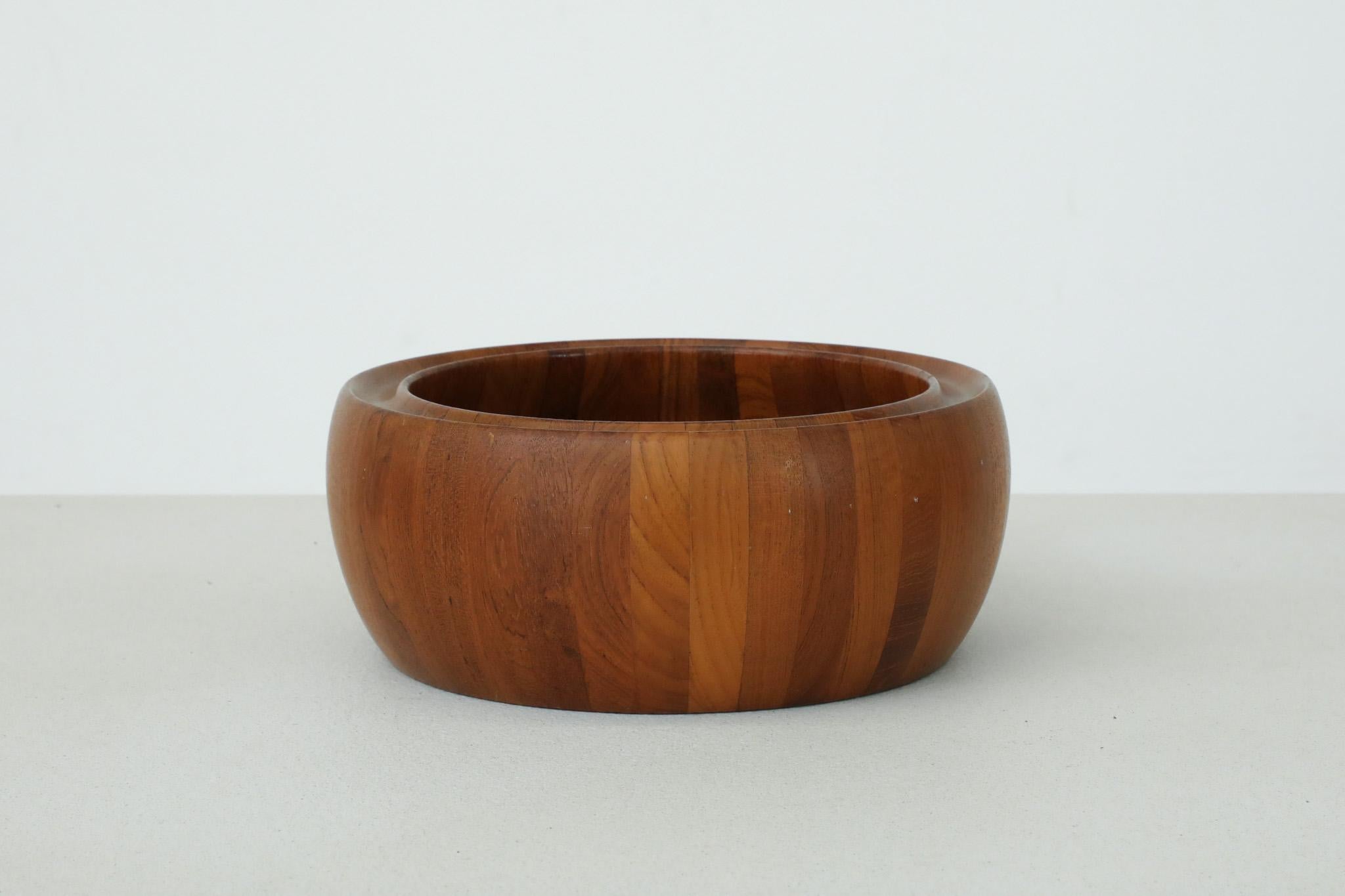 Precioso cuenco redondo Digsmed de mediados de siglo, con atributo danés, de madera de teca tallada y borde grueso decorativo. En estado original con desgaste visible acorde con su edad y uso.