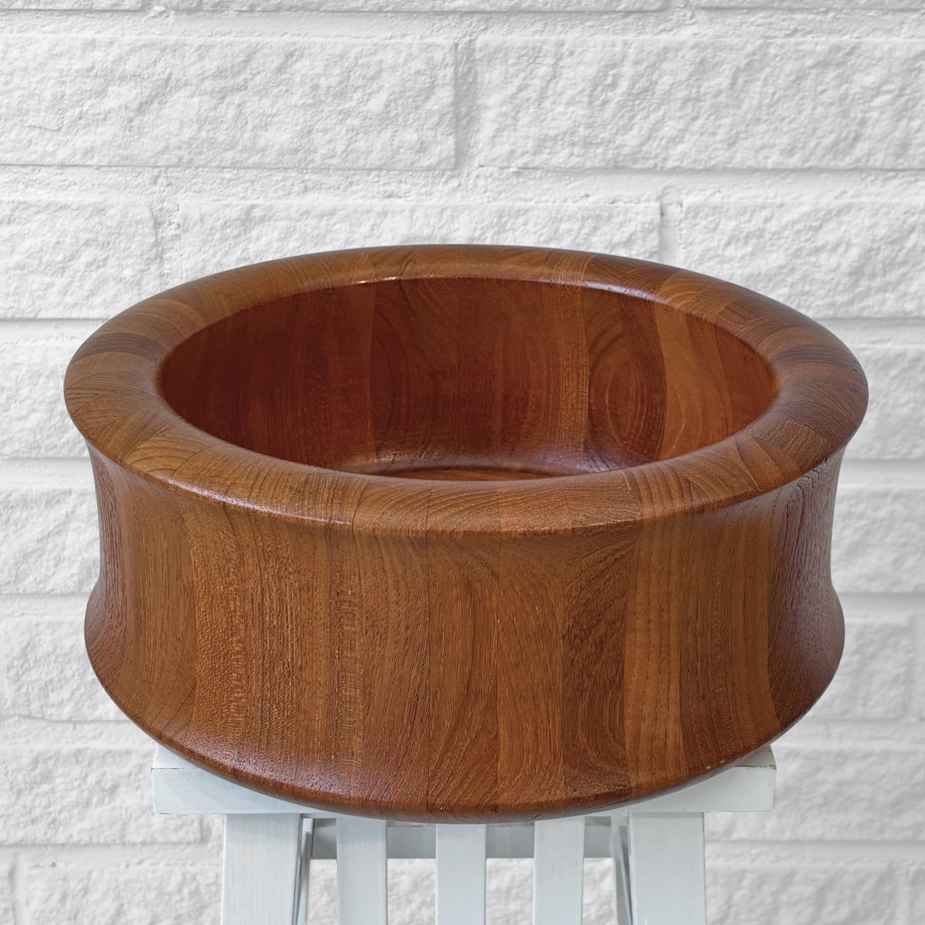 A large sculptural salad bowl crafted from solid teak, designed by Flemming Digsmed and produced by the Danish manufacturer Digsmed in the 1960s. An impressive piece turned from laminated wood, both sculptural and minimalistic. Perfect for serving