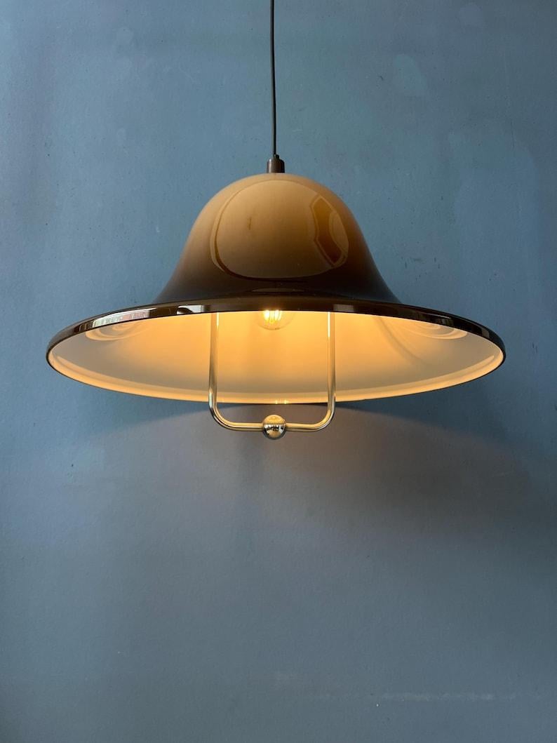 Incredibile lampada a sospensione in vetro acrilico di Dijkstra. Questo pezzo dell'era spaziale è realizzato in plexiglass spesso e di colore marrone caffè. La lampada diffonde una luce calda. La lampada richiede una lampadina E27/E26.

Informazioni