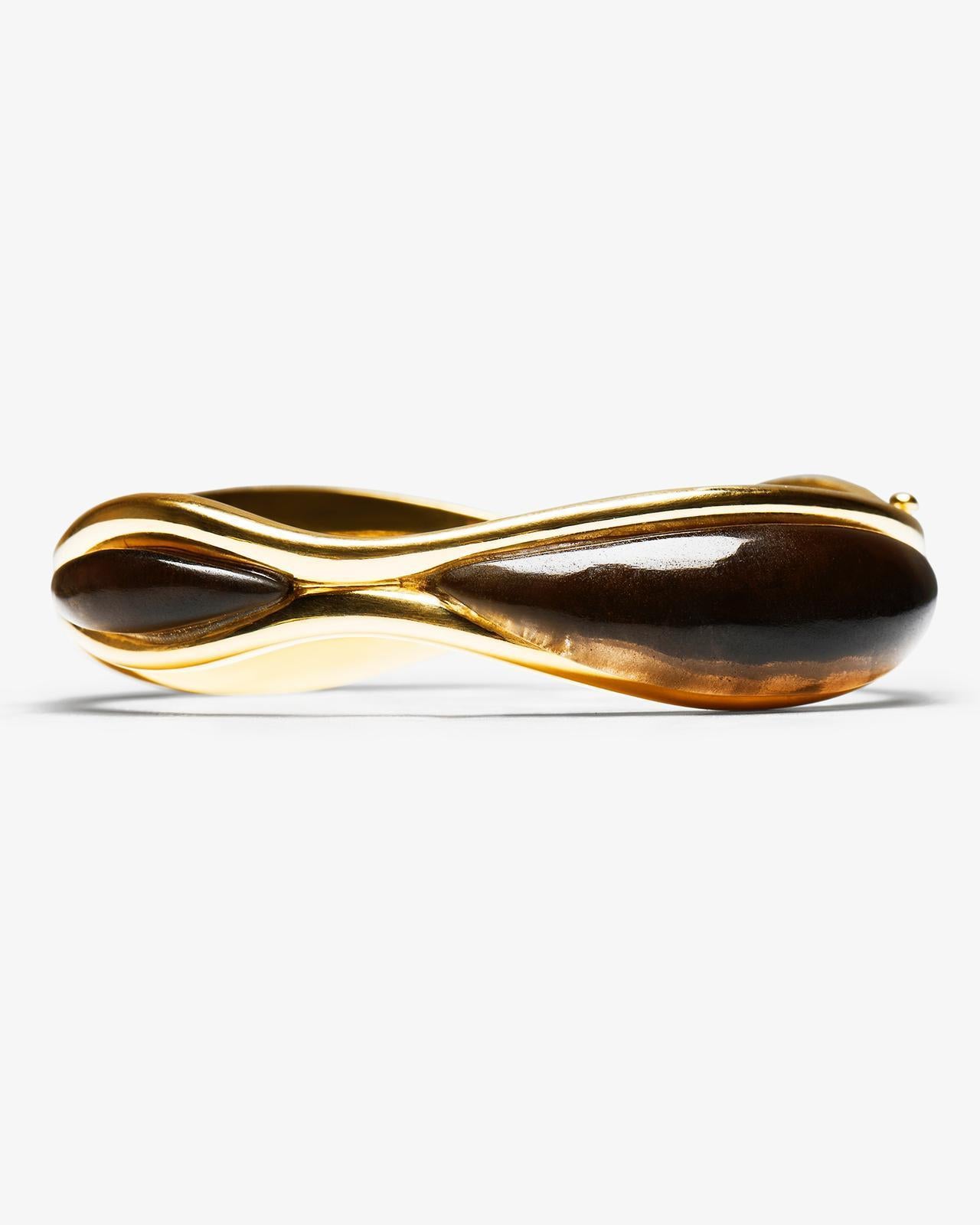 DILHAN Bracelet SU en or jaune éthique 18k, quartz fumé. Une variation sur le traditionnel bracelet en or, avec deux formes de vagues entrelacées qui se rejoignent et se séparent sur sa circonférence. Traduisant le jeu de l'ombre et de la lumière