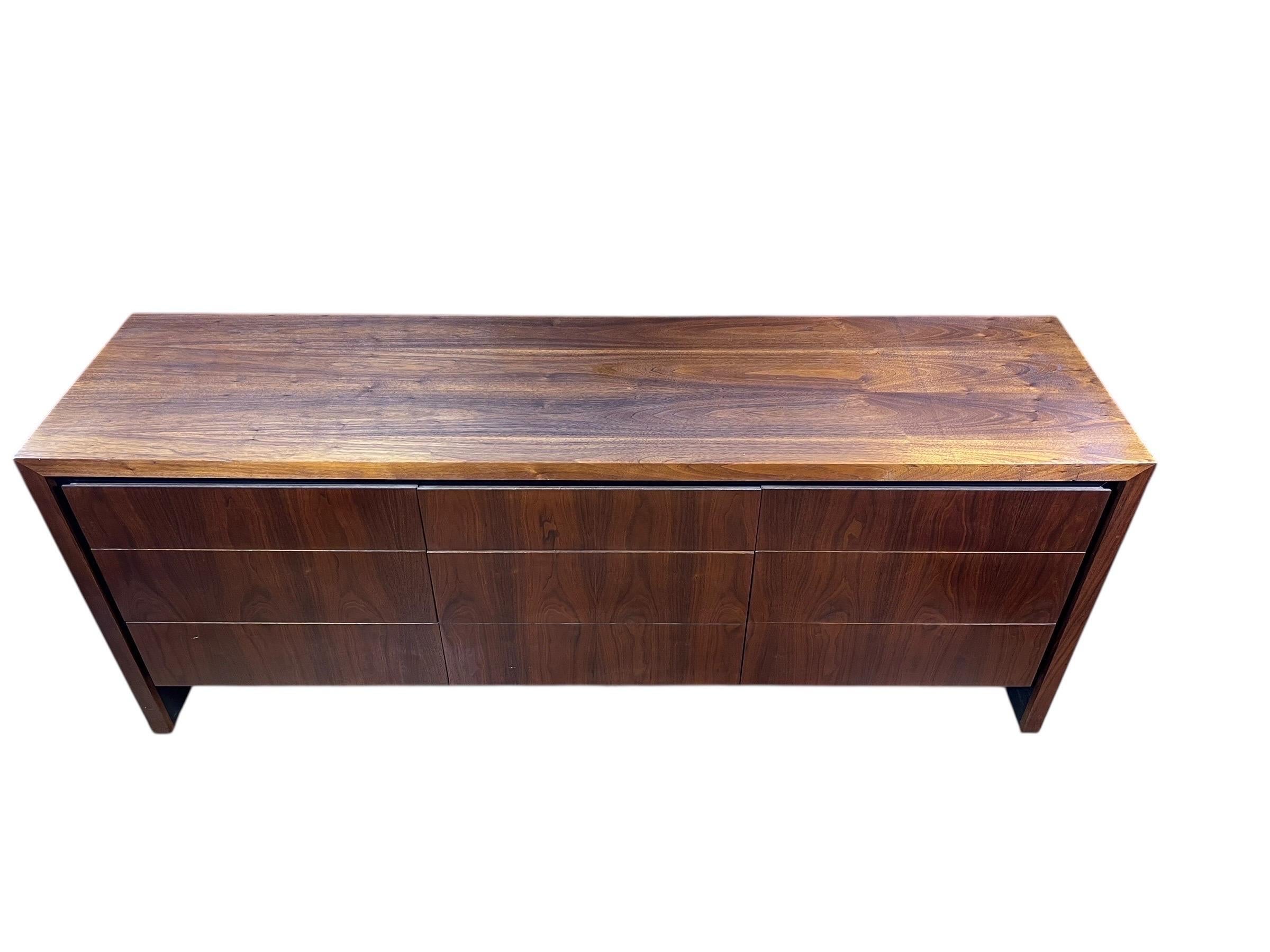 In vendita c'è un comò basso vintage di grandi dimensioni, caratterizzato da splendide venature del legno e che conserva l'etichetta originale. Questo pezzo combina un fascino classico con un fascino senza tempo.