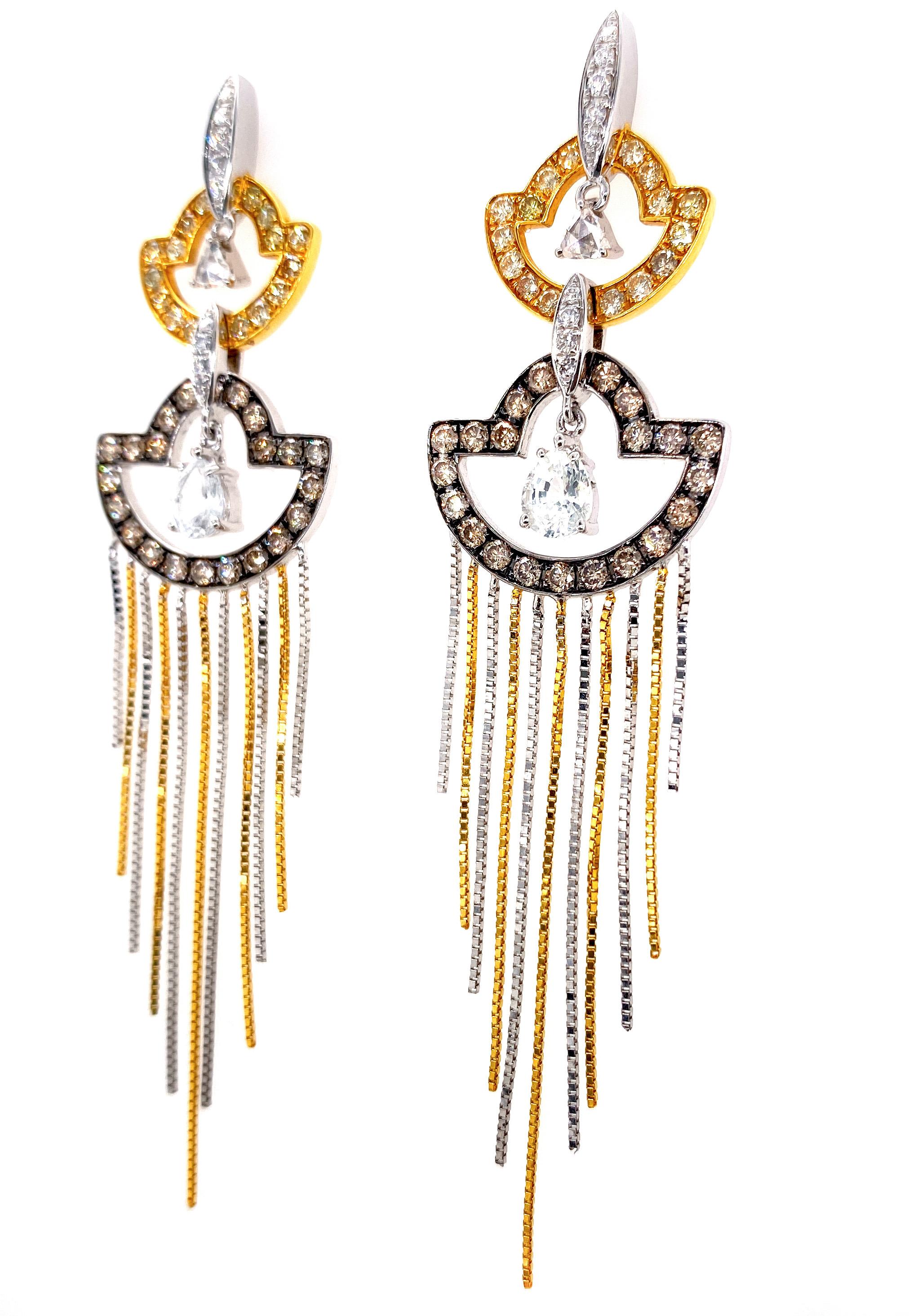 A stunning pair of 18 karat yellow, white and black gold earrings by Dilys’, designed with a touch of Old Hollywood grandeur. Set with 74 fancy color diamonds totaling 1.28 carats, 20 white diamonds totaling .25 carat and 2 white sapphires, the