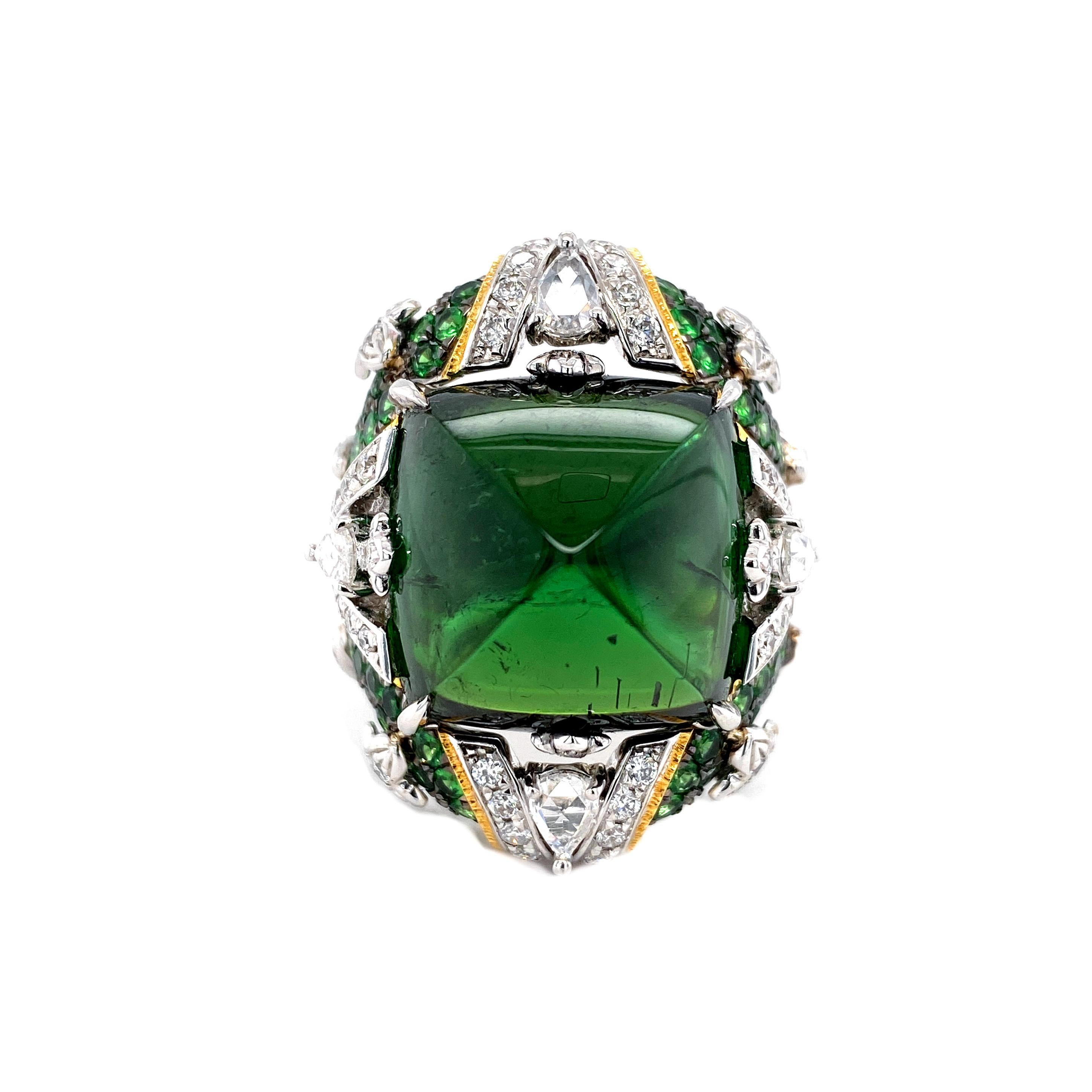 A very rare find with an exquisite transformable design, featuring the ring jacket, unique to Dilys' High Jewellery.  

1 GRS Certified Unheated Green Tourmaline in Sugarloaf Cut, totalling 24.82cts. 
76 Green Garnets, totalling 1.98cts.
70