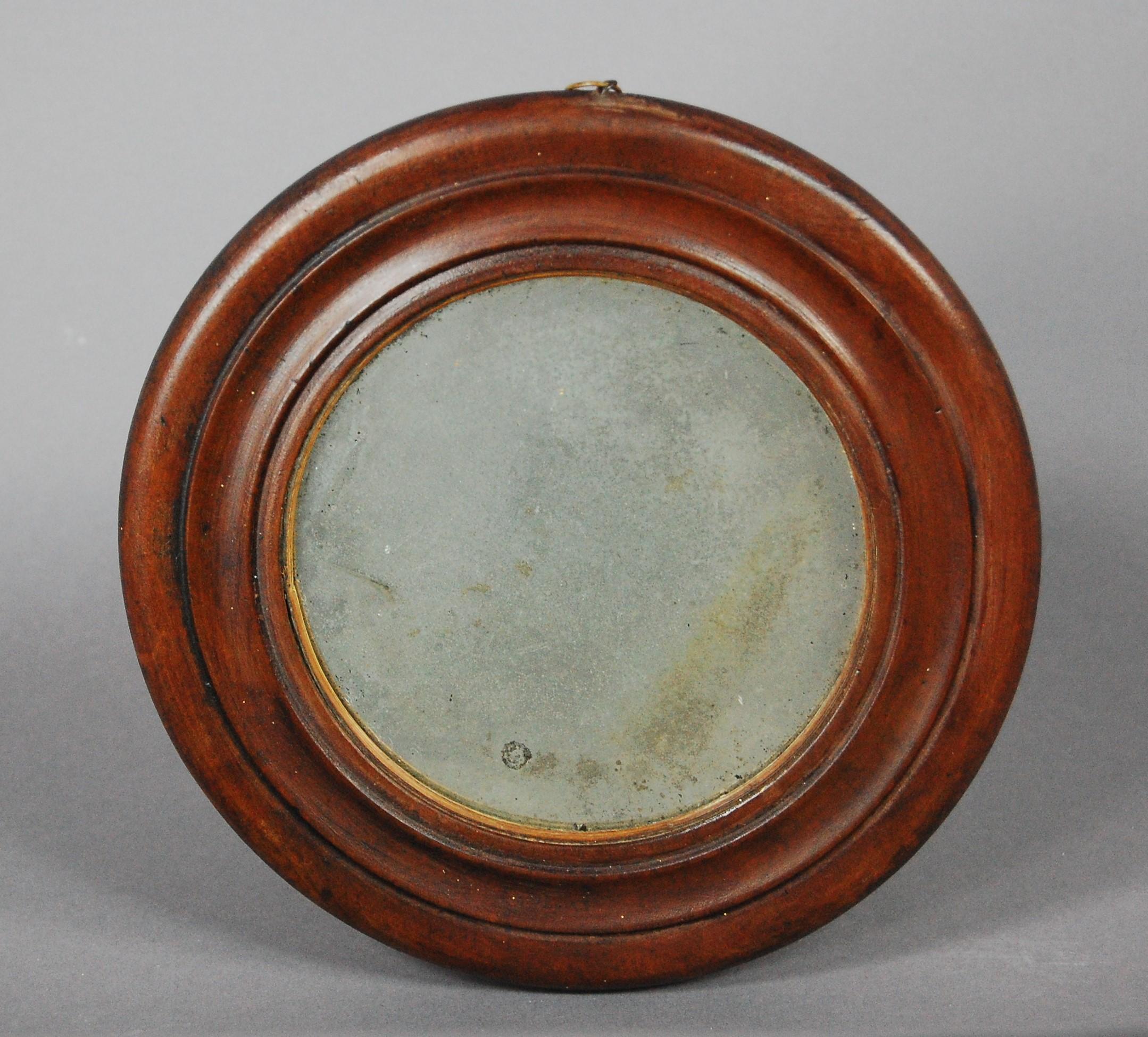 Diminutive circular 19th century mirror with original foxed mercury plate.
  
