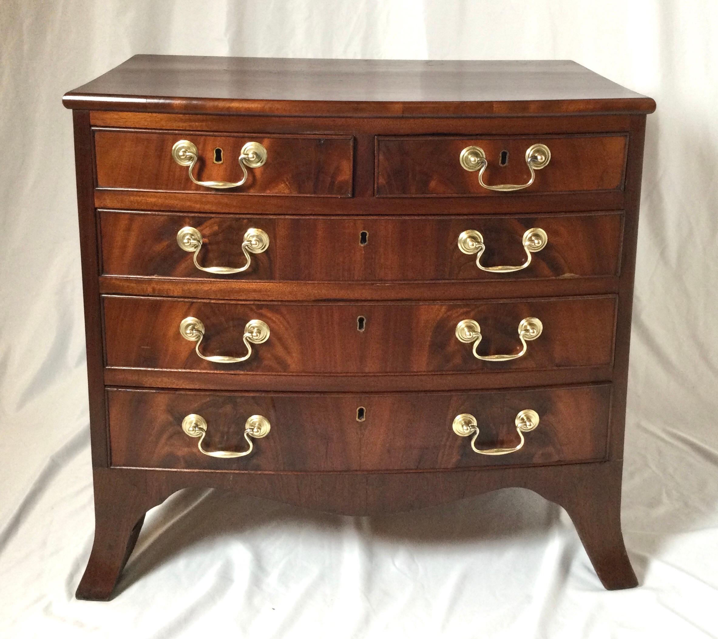 An elegant smaller solid mahogany chest of drawers with original brass hardware. The two drawers over three larger drawers resting on four splayed bracket feet. The finish has been refreshed around 50 years ago and remains in very good well cared