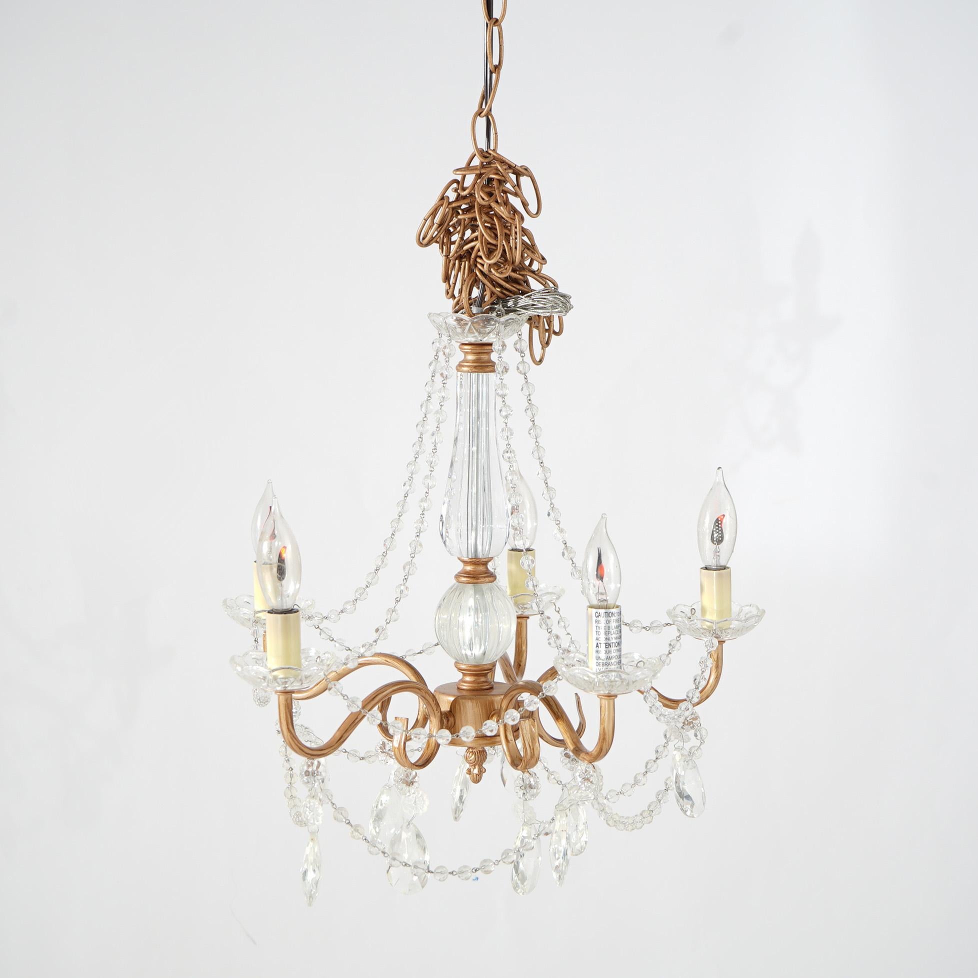 A diminutive chandelier offers brushed copper frame with five scroll form arms terminating in candle lights, hung and strung crystals throughout, 20th century

Measures - 15.5