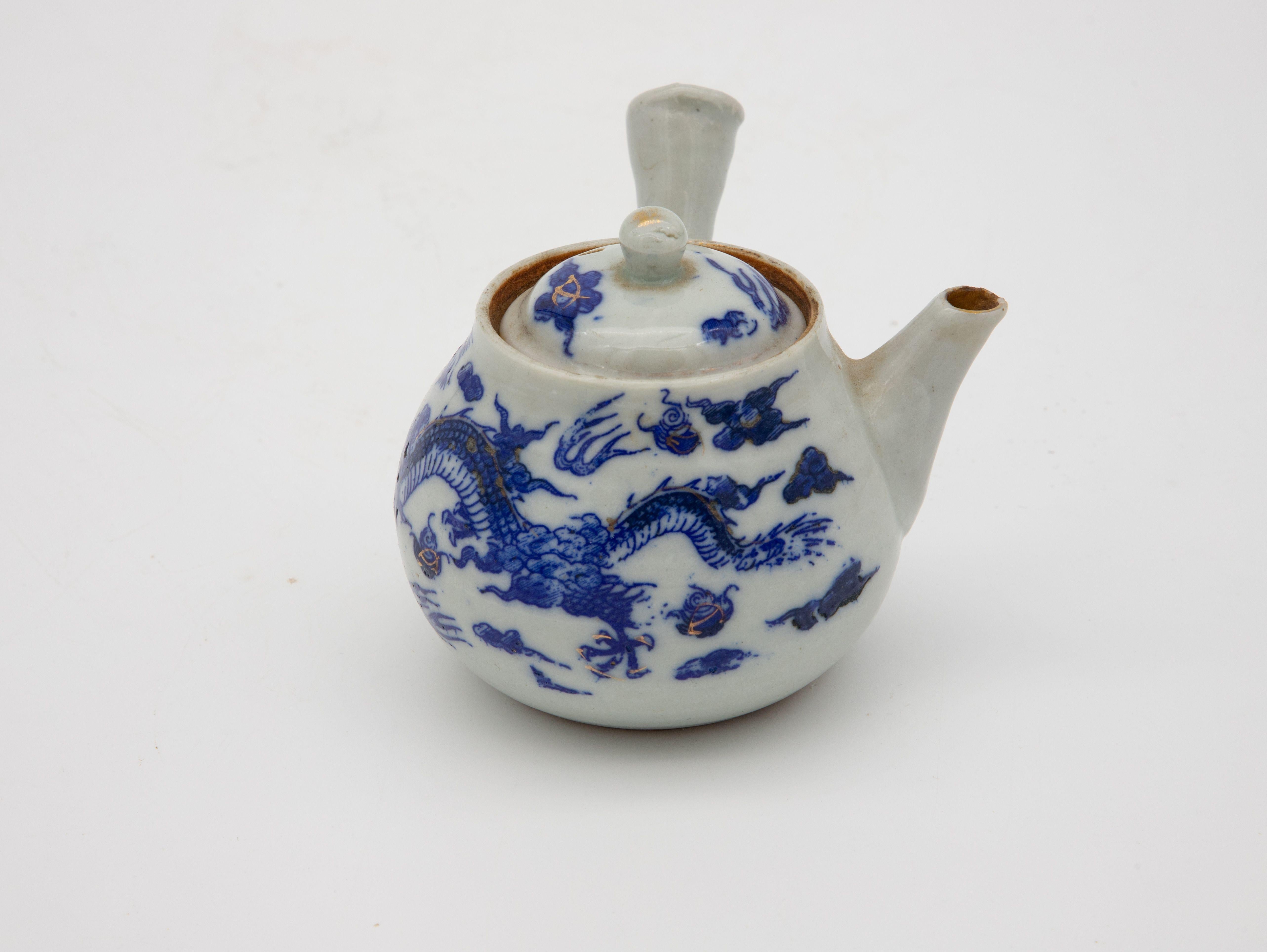 A diminutive Chinoiserie teapot featuring a dragon. Early 20th century in the classic blue and white colors the style is known for.