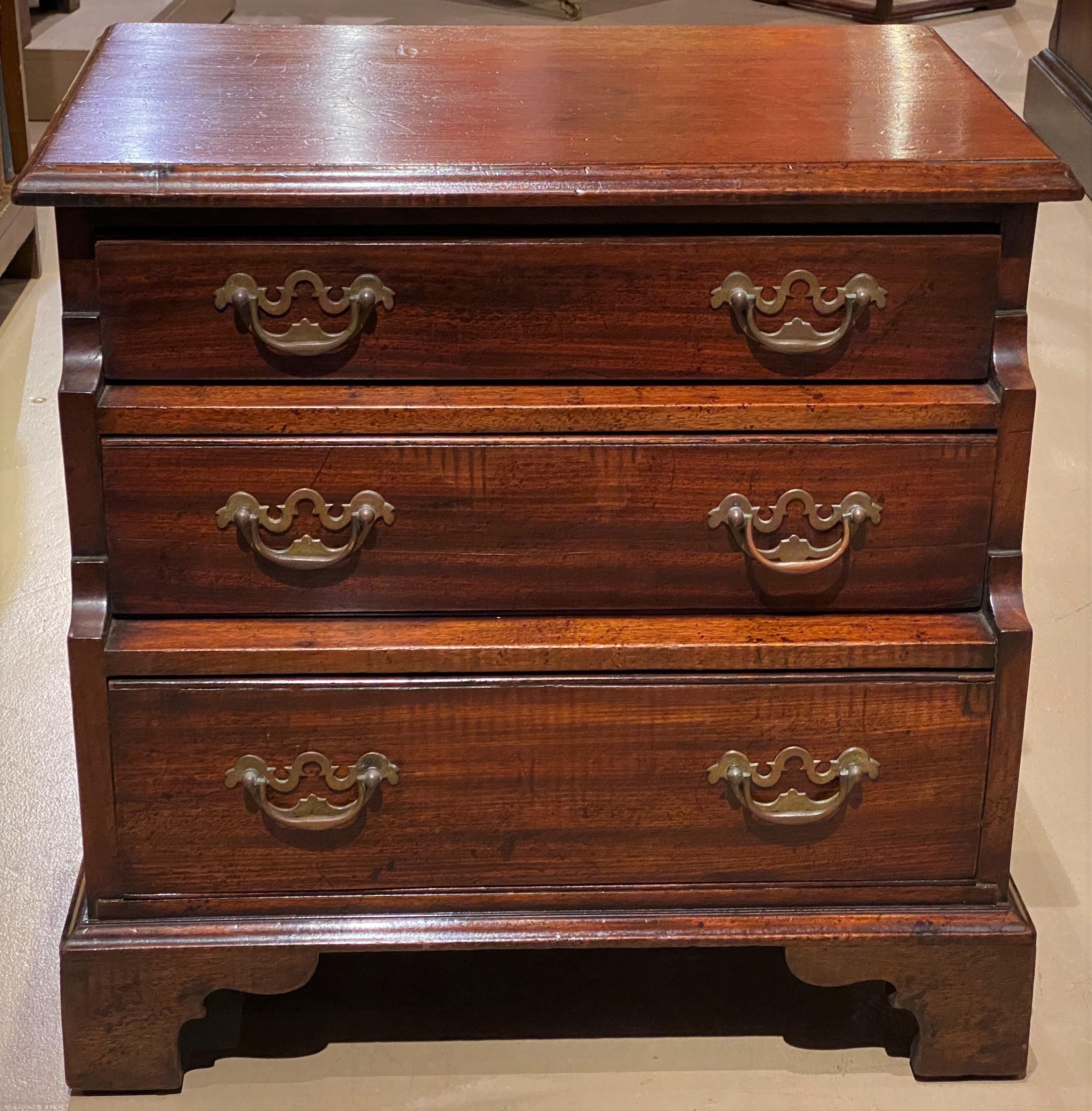 A fine diminutive English Chippendale style mahogany chest or side table with a rectangular molded edge top surmounting three graduated drawers on a nicely carved bracket base, with chamfered drawer bases, and great patina. Very good overall