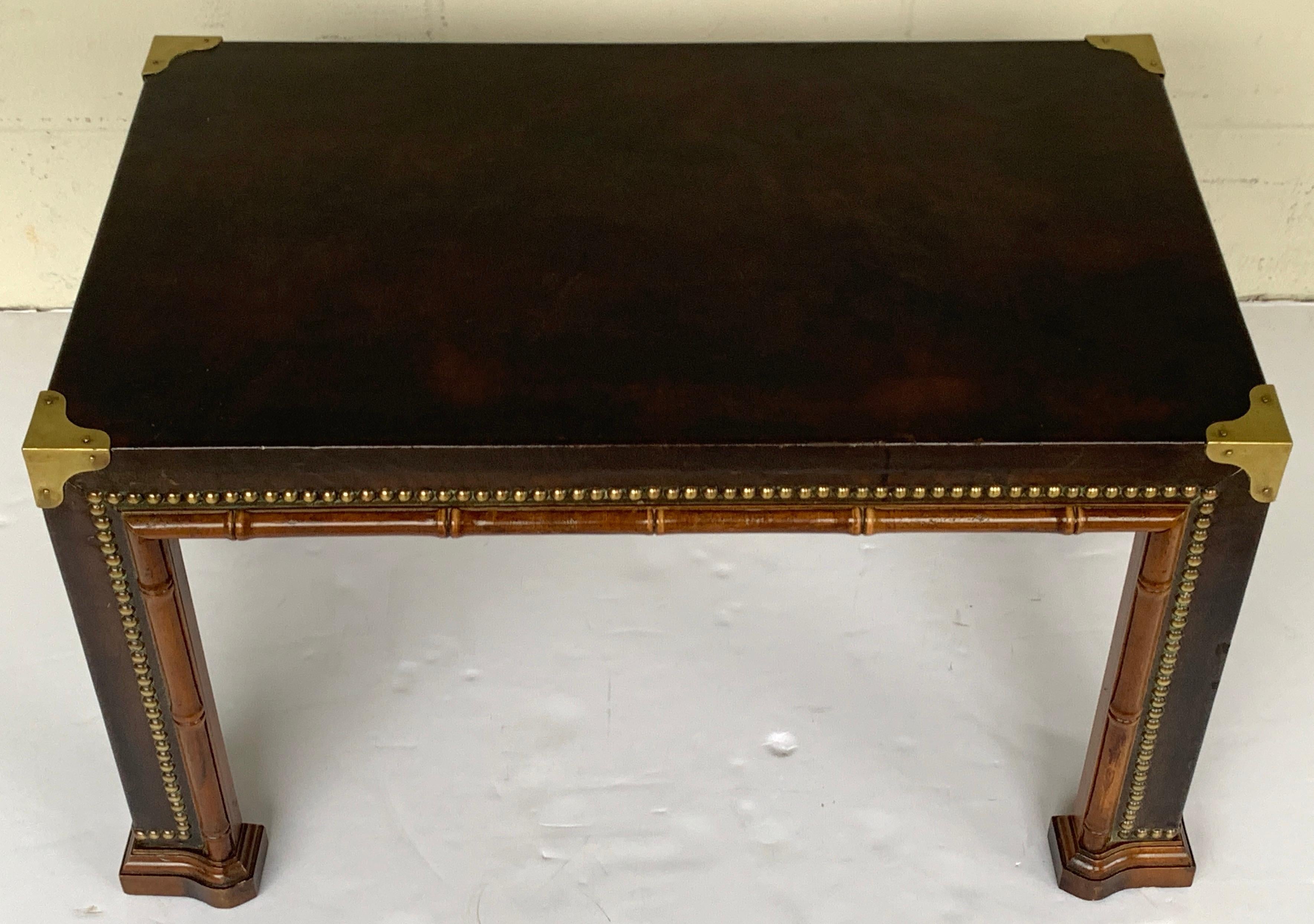 Diminutive faux bamboo brass studded & leather coffee table, of rectangular form with four brass corners, leather wrapped top and legs with continuous brass nail heads. 

