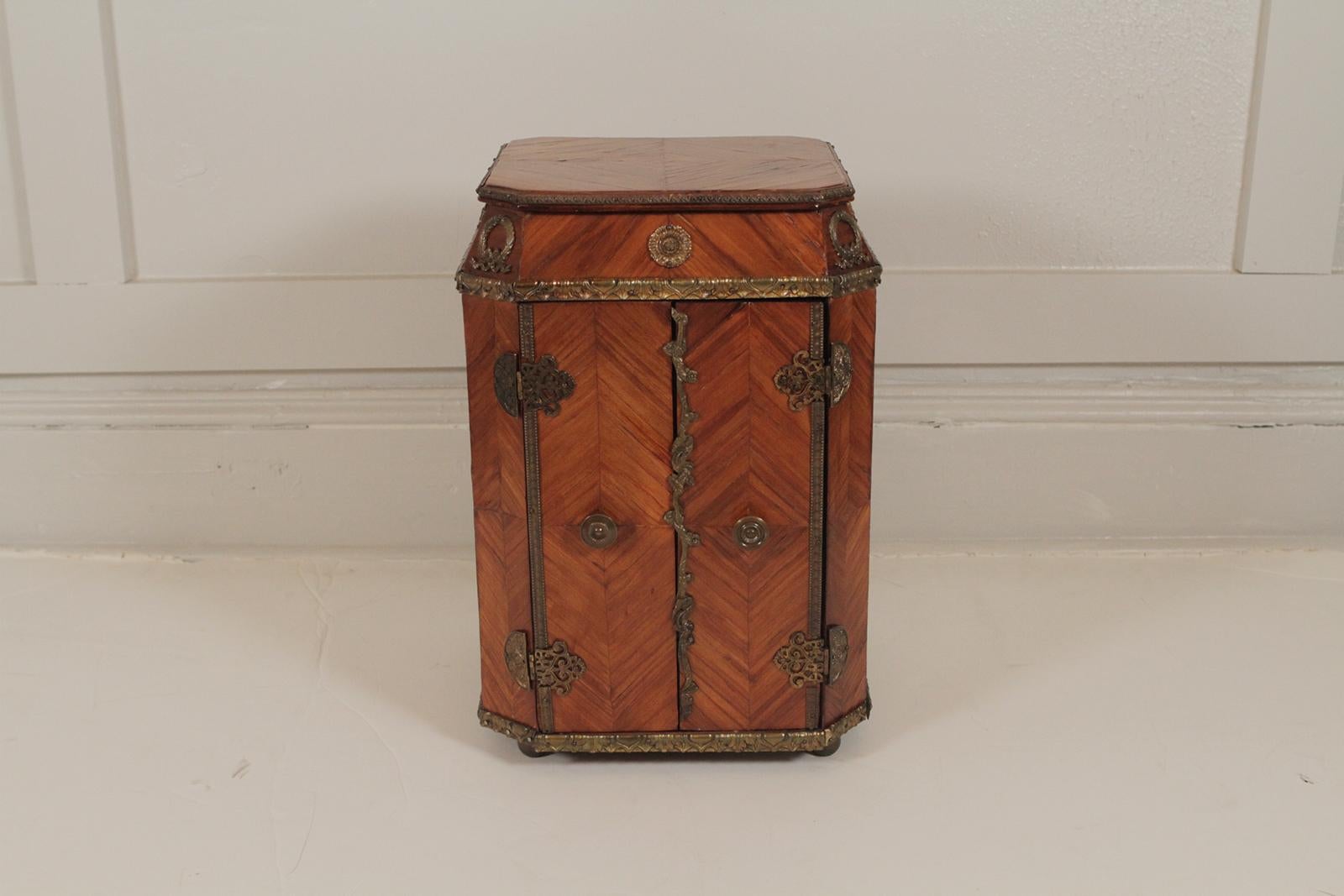 A French miniature doored chest in tulipwood with gilt bronze mounts. The diminutive chest with two doors that open to reveal five drawers. Beautiful tabletop chest for jewelry or other treasures.
 