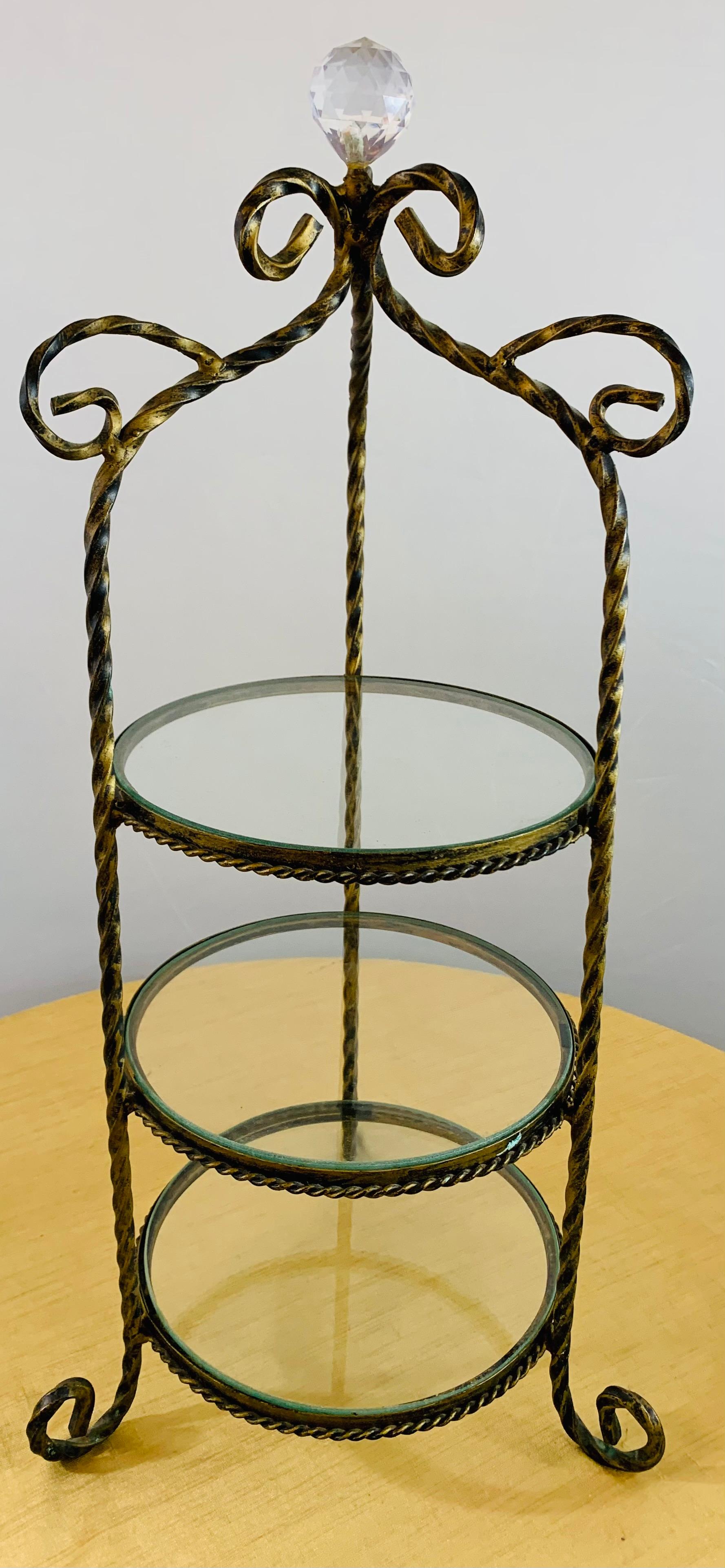 A vintage diminutive French handmade wrought iron étagère. Featuring round glass shelves and scroll feet and a crystal prism on the top, the decorative étagère is finely gilt painted in an antiqued fashion.


Dimensions: 23