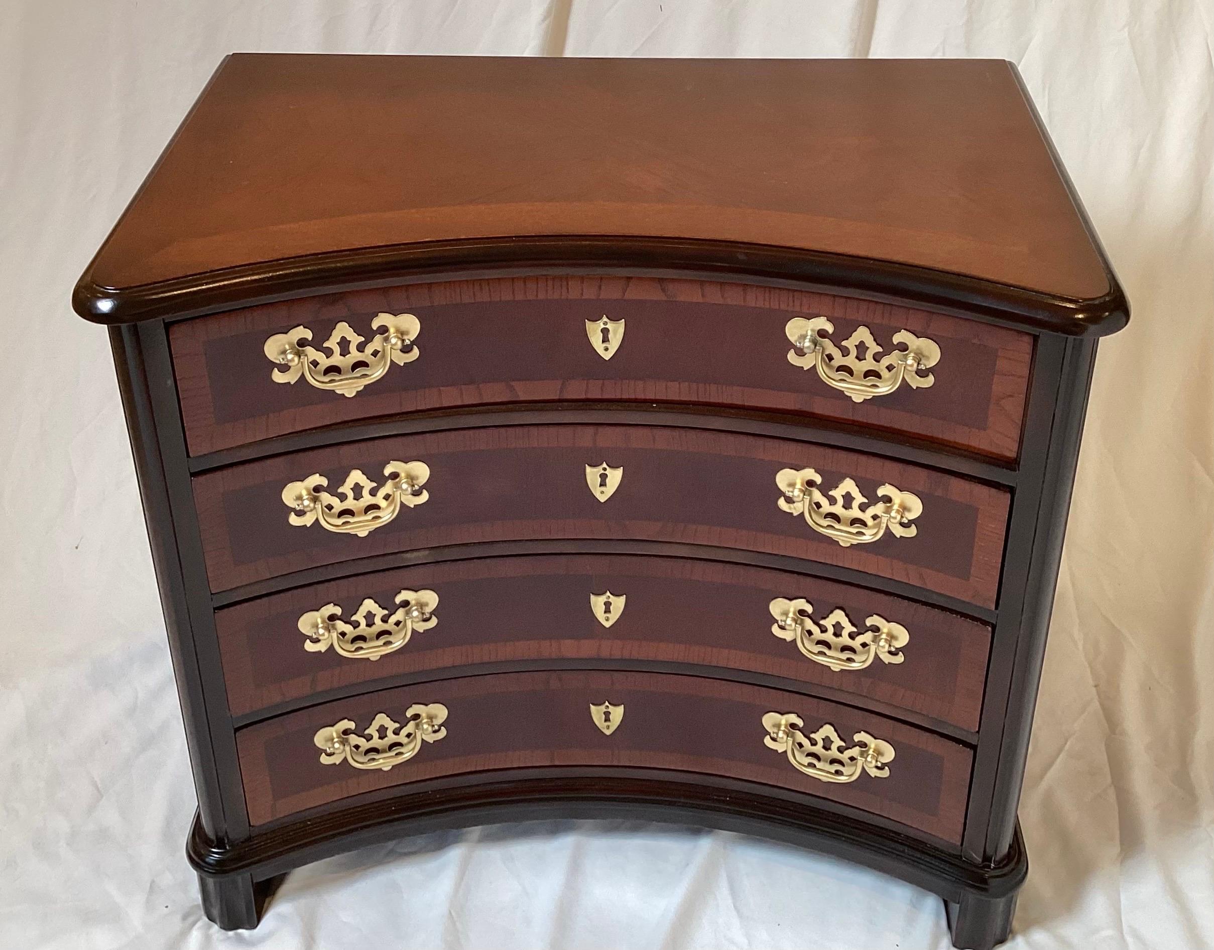 Elegant Mahogany chair side chest. The unique convex front with four drawers with pierced brass Aladdin's lamp pulls.  The rich mahogany wood with cross banding and book matched veneers