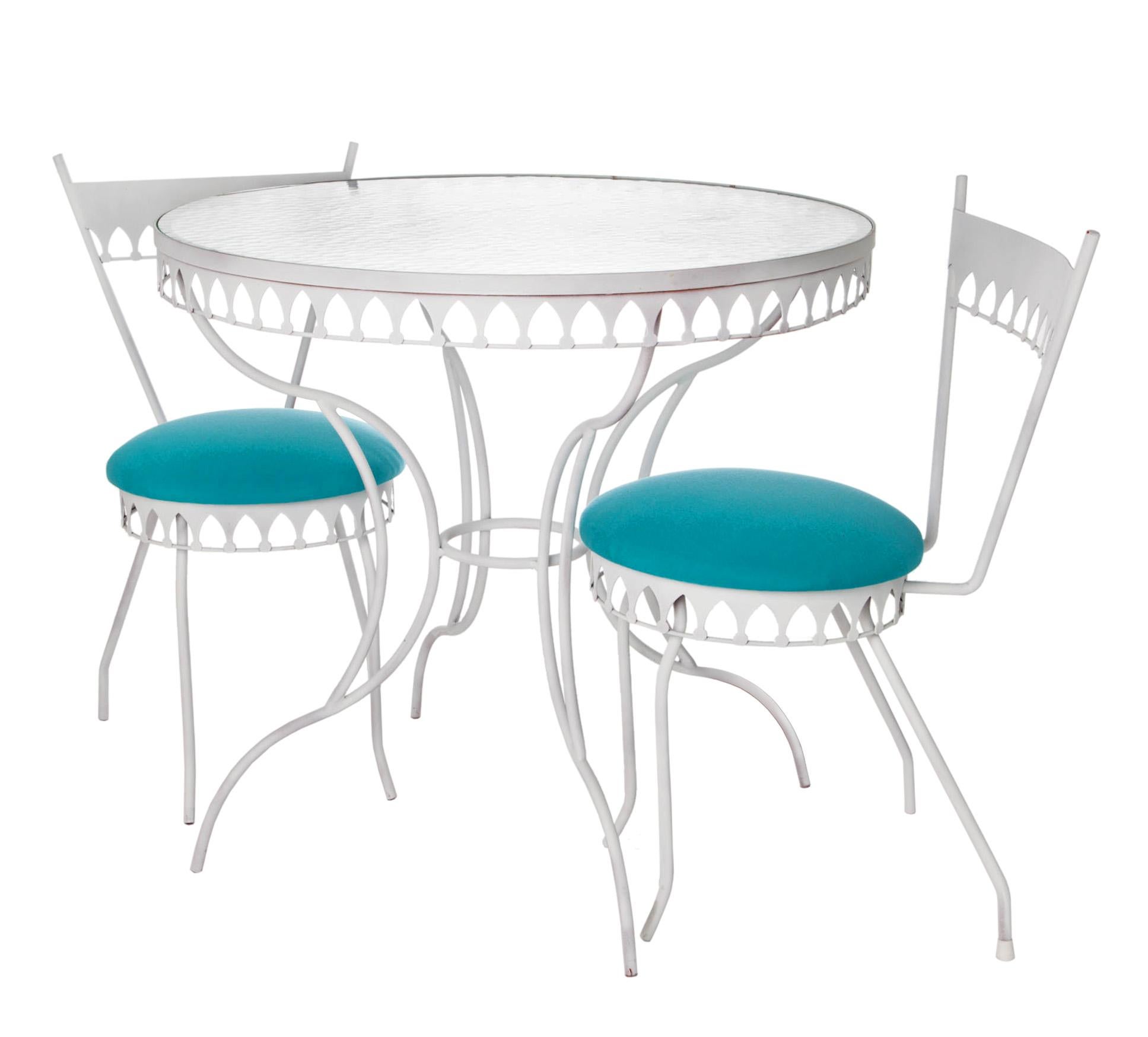 Iconic mid-century Moorish style café table with two small chairs, upholstered in aqua Sunbrella.
Perfect set for a balcony or other tight space. The two petite chairs have a  round back that hugs the back.
The seats are new inside & out. 
The round