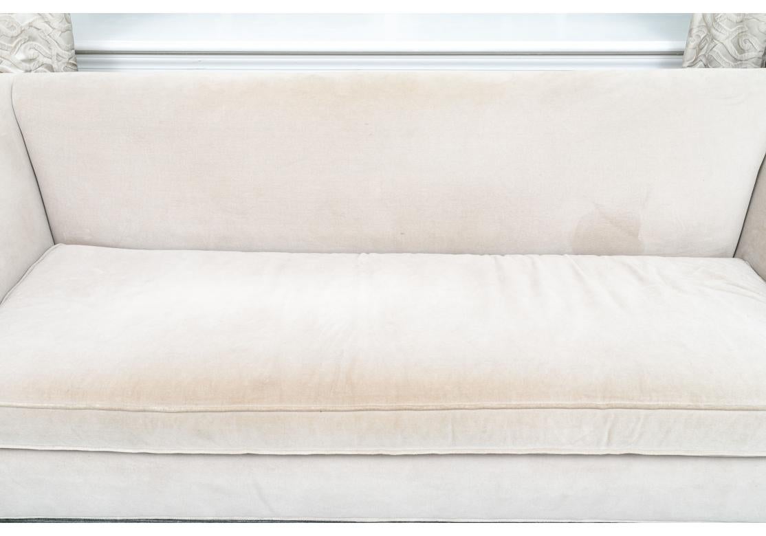 Un elegante Sofá de un solo cojín con formas refinadas, brazos en ángulo y patas cónicas. Muy cómodo y tapizado en un fino Terciopelo Ostra con las almohadas en un tejido estilo Mohair en un tono ligeramente más claro. El Sofá tiene un tamaño más