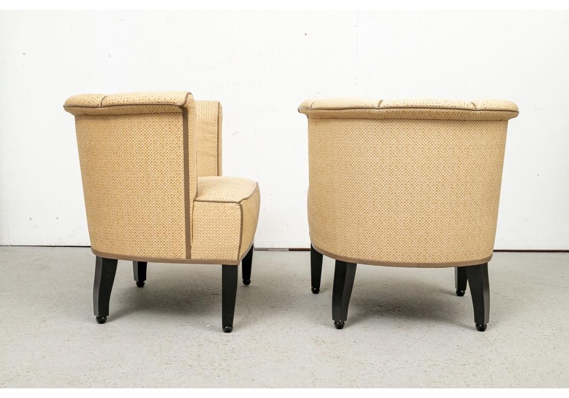 A more modest sized Pair of club chairs in a custom treatment with all of the comfort of a full sized pair. The style of the Club chairs in the mid century manner, well constructed with tufted tub backs, high sides with rolled crest rail and arms.