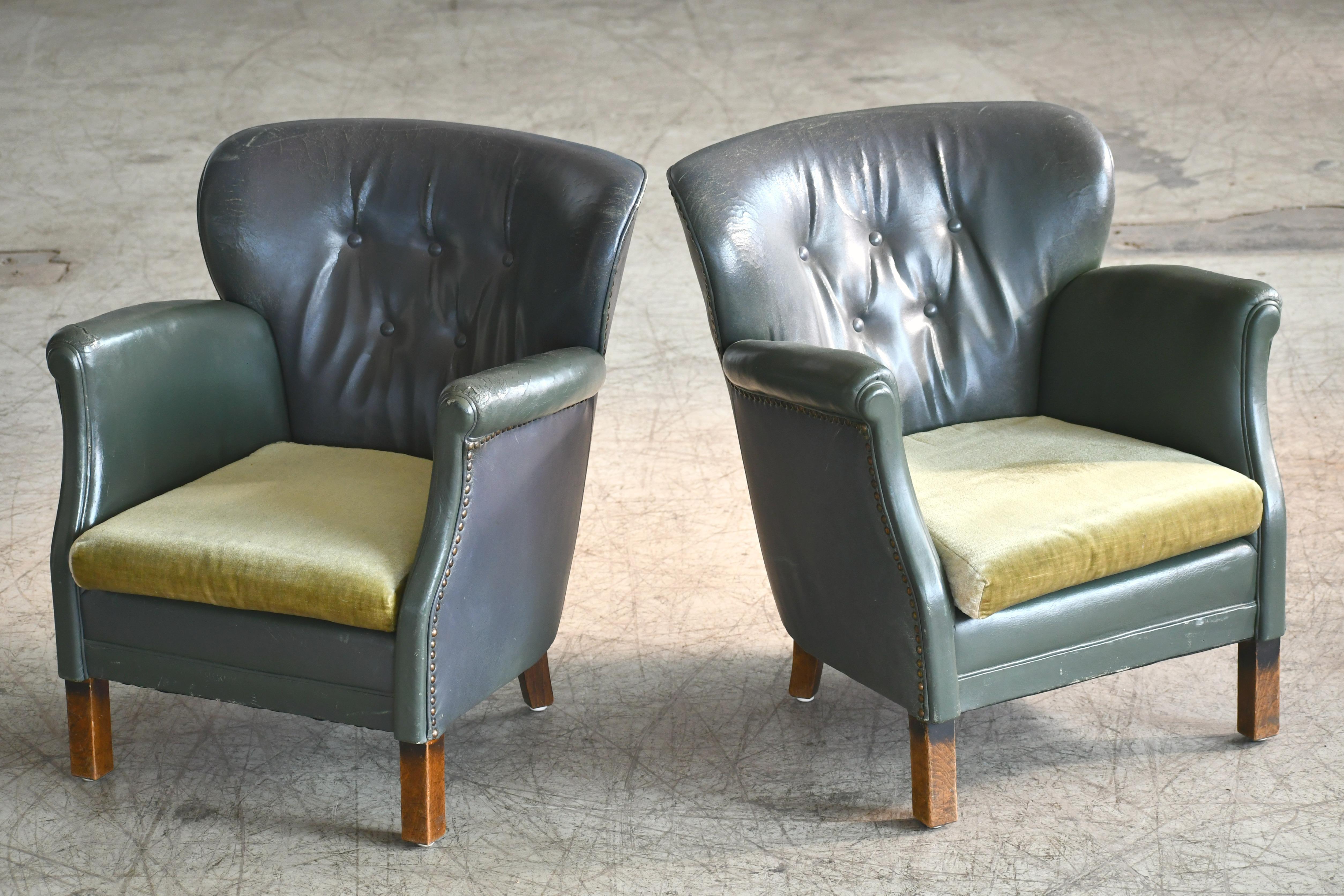 Charming pair of diminutive Danish club armchairs made by Danish Furniture Maker Oskar Hansen around the mid-1930s. Tufted back most often found from this period. Covered in original green leather with tufted back. The chairs show some wear and a