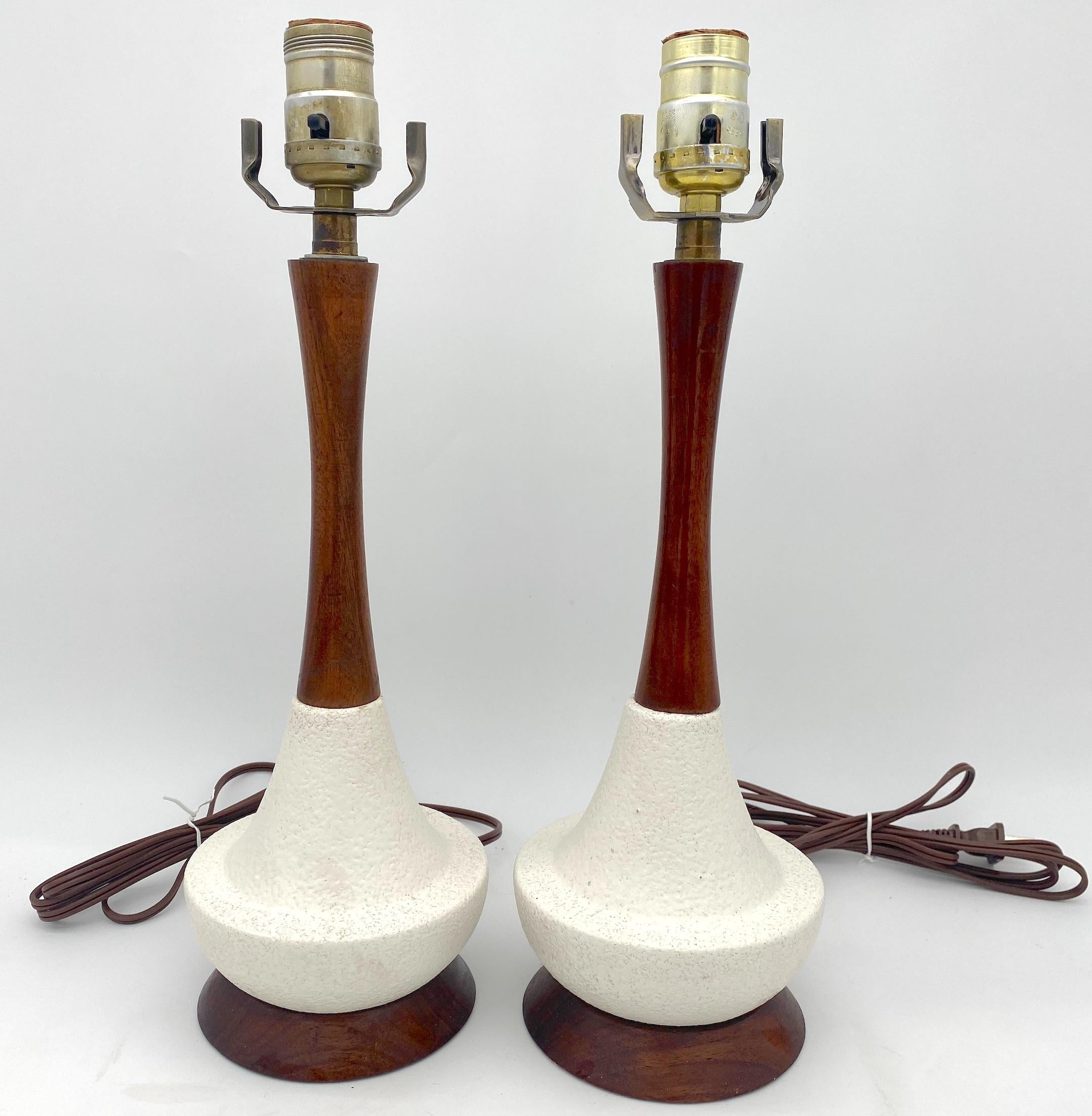 Diminutive  Pair of Danish Modern Carved Teak Wood & White Porcelain Lamps 
Denmark, circa 1960s

Illuminate your space with this charming pair of Diminutive Danish Modern Carved Teak Wood & White Porcelain Lamps from the 1960s. Crafted in Denmark,