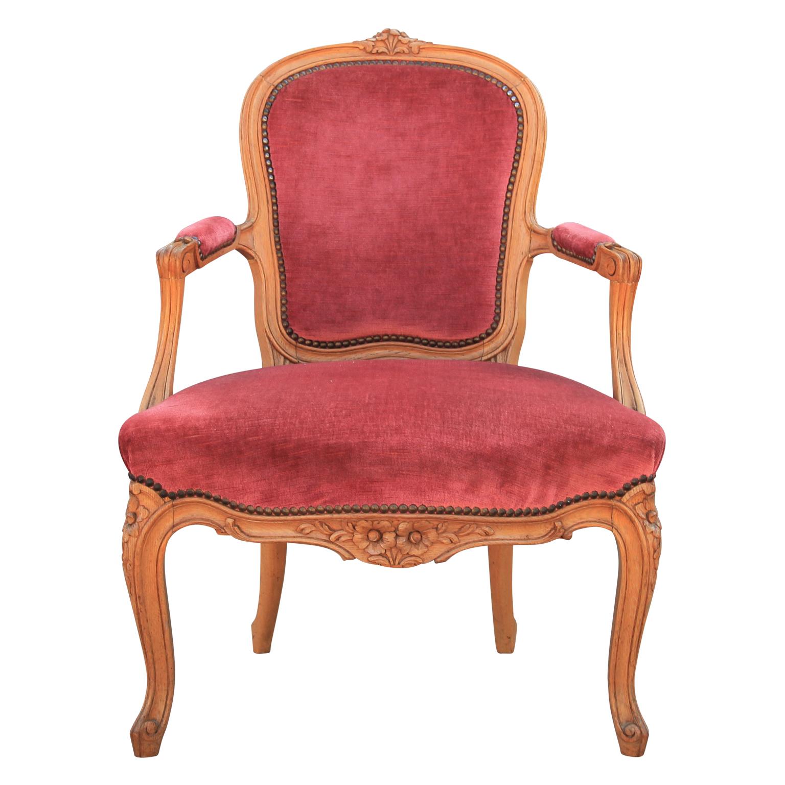 Stylish pair of walnut armchairs that include a solid frame with decorative floral carvings. The body of each chairs also includes padded arms and a solid backrest. Needs New upholstery.