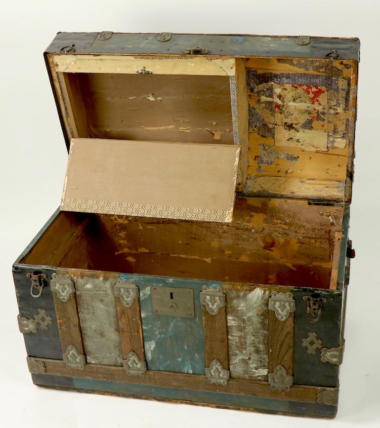 Diminutive antique dome top truck with polychrome metal sides and wood strap construction. The interior includes the original lift out tray. The tray shows some wear, specifically the lift up lid has separated into two parts (see images). Unusual