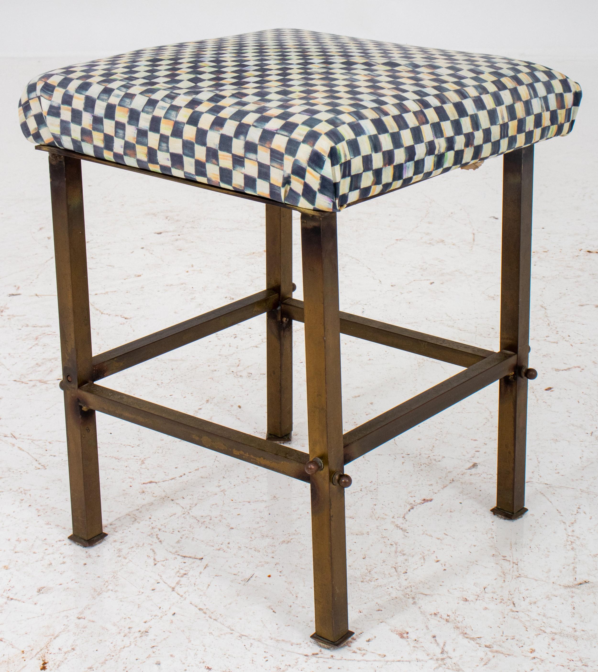 Diminutive square brass stool. Here's a breakdown of its key features:

Material: Brass - The frame of the stool is made of brass, likely polished for a shiny gold appearance.
Size: Diminutive - The small size suggests it's not intended for regular