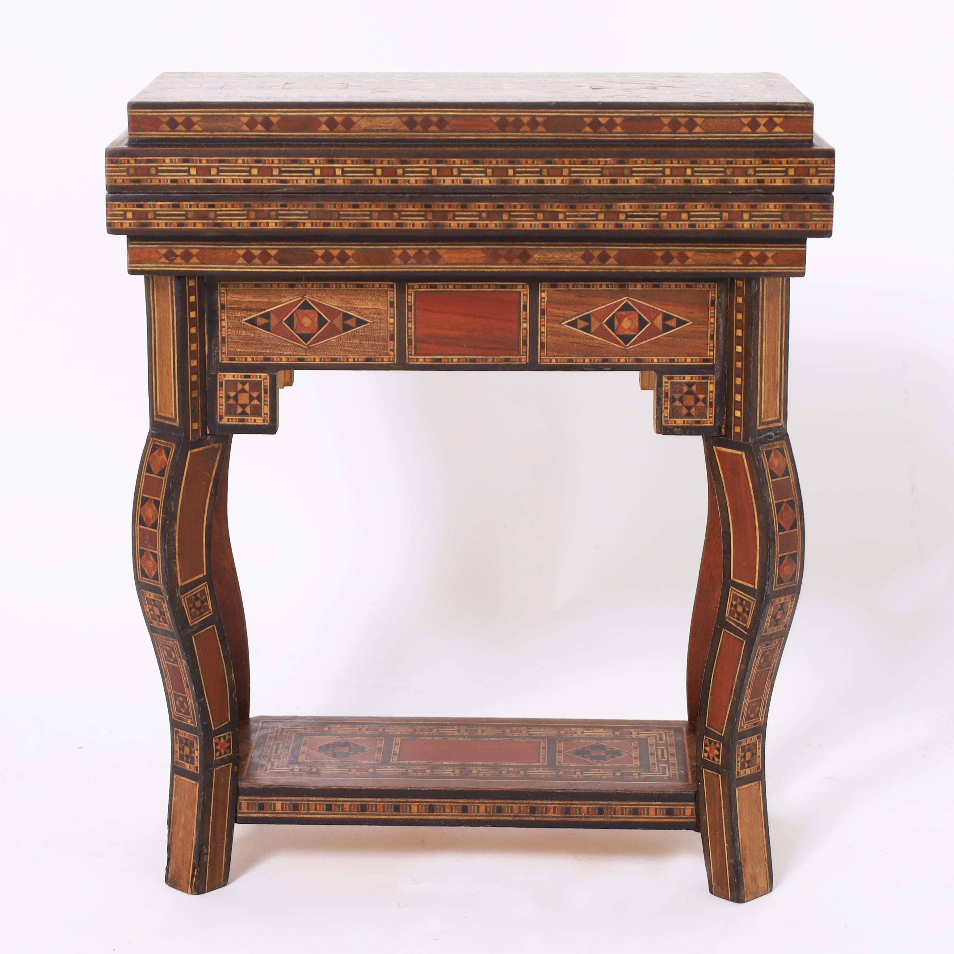 Impressive miniature table top Moroccan games table crafted in walnut featuring elaborate inlaid marquetry with mother of pearl, mahogany, kingwood and ebony, flip top games including chess, backgammon and cards, cabriole legs and an inlaid lower
