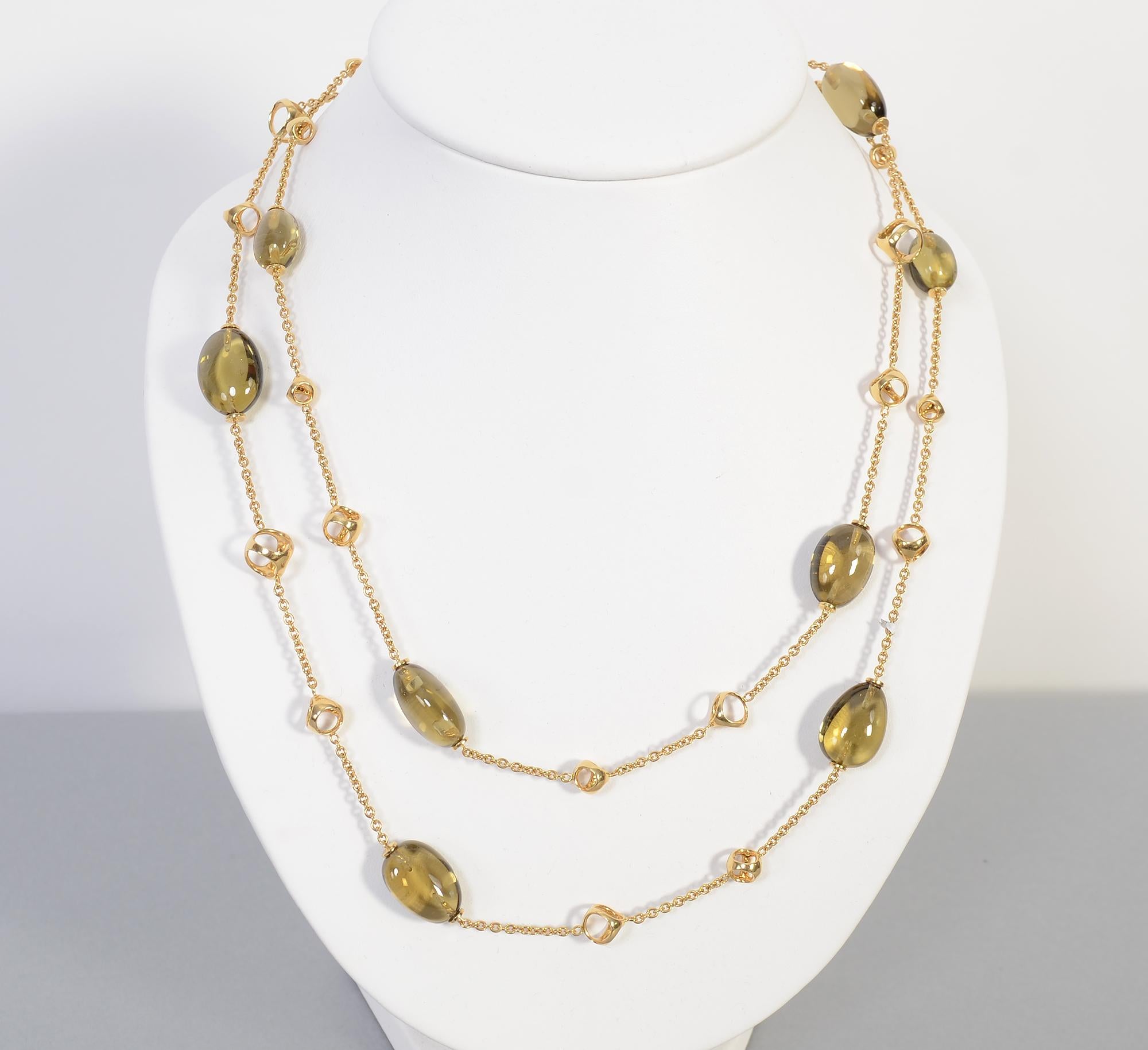 Fashionable and unusual 18 karat gold chain necklace with egg shaped citrines. The stones have a greenish tone.  Alternating with the citrines are graduated size open triangular gold links. The necklace measures 41 inches long. It has a clasp so it