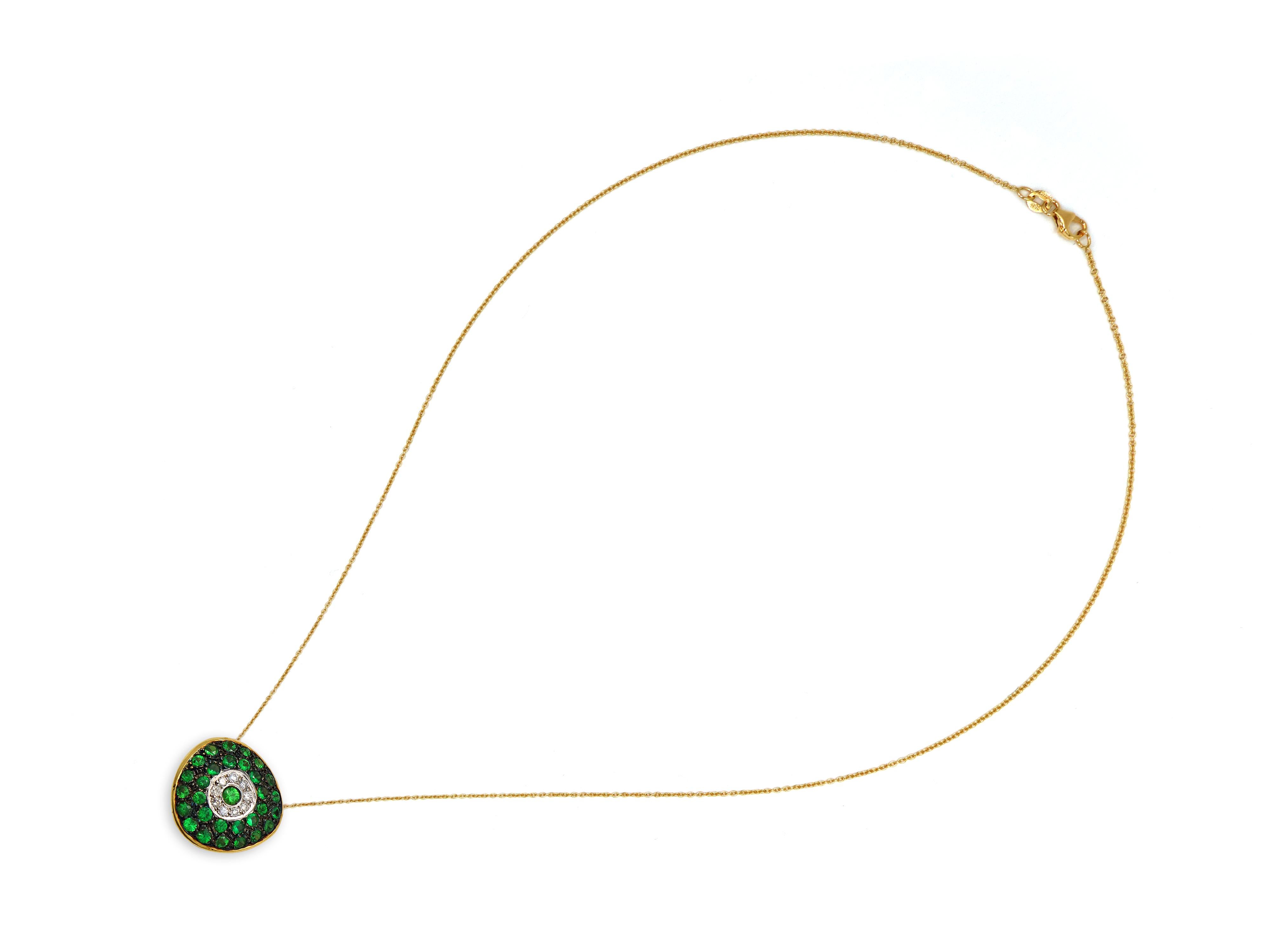 Abstract evil eye in 18 karat yellow gold set with 1.30 carats Tsavorites and 0.10 brilliant cut Diamonds.  A larger size evil eye in an off round shape that hosts the chain behind the stones and creates a very minimal and smooth necklace. Most eyes