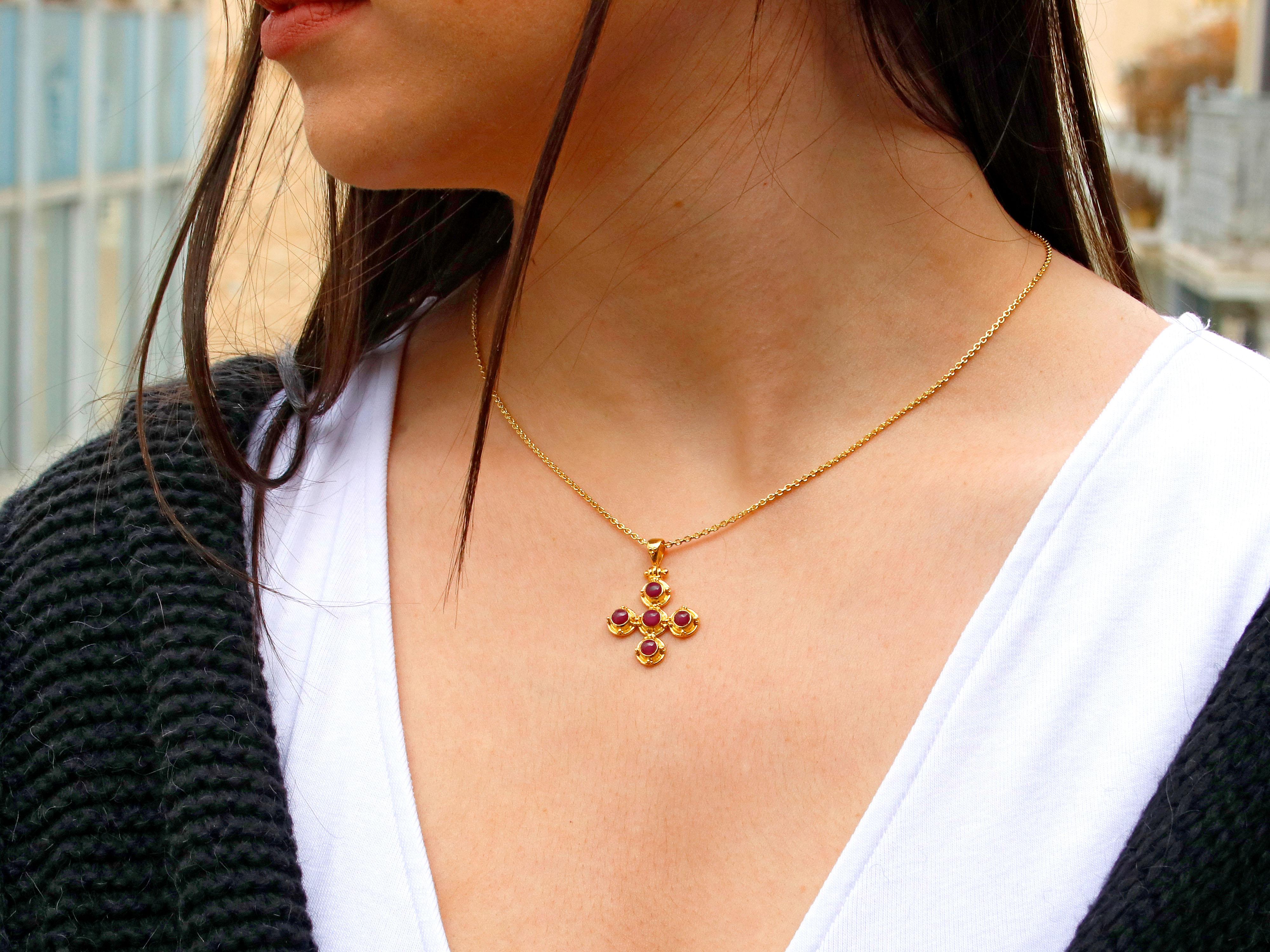  18k gold cross pendant with rubies and granulation decoration that combines elegance and religious symbolism.

The cross is adorned with rubies, which are precious gemstones known for their vibrant red color. Rubies have long been associated with