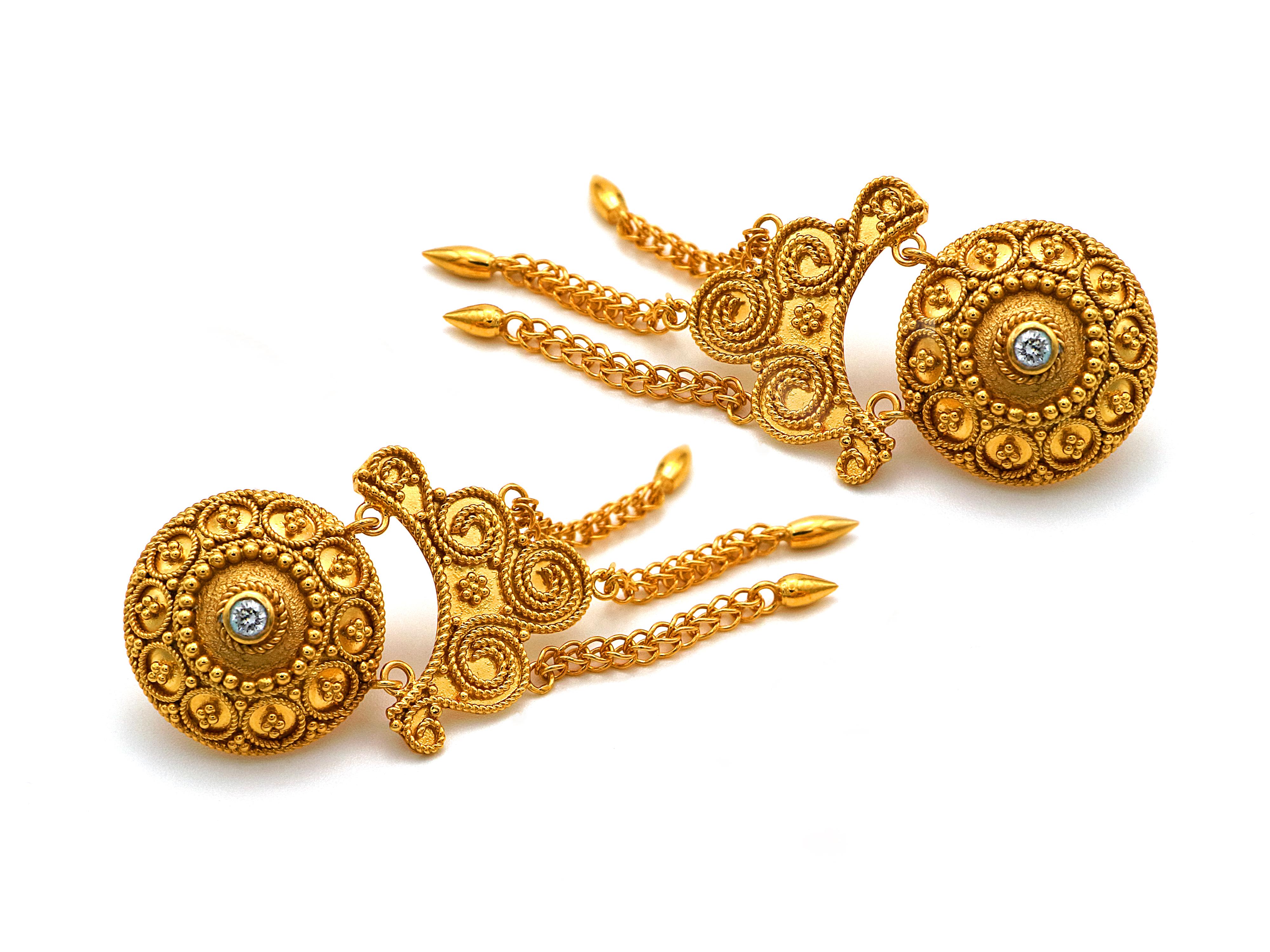 Neoclassic bottom earring with granulation and filigrees on the earlobe and a touch of the Greek seas dangling under it. 
The waves are made out of filigree, attached to them you can see a handmade chain finishing in spheres. The center domes host