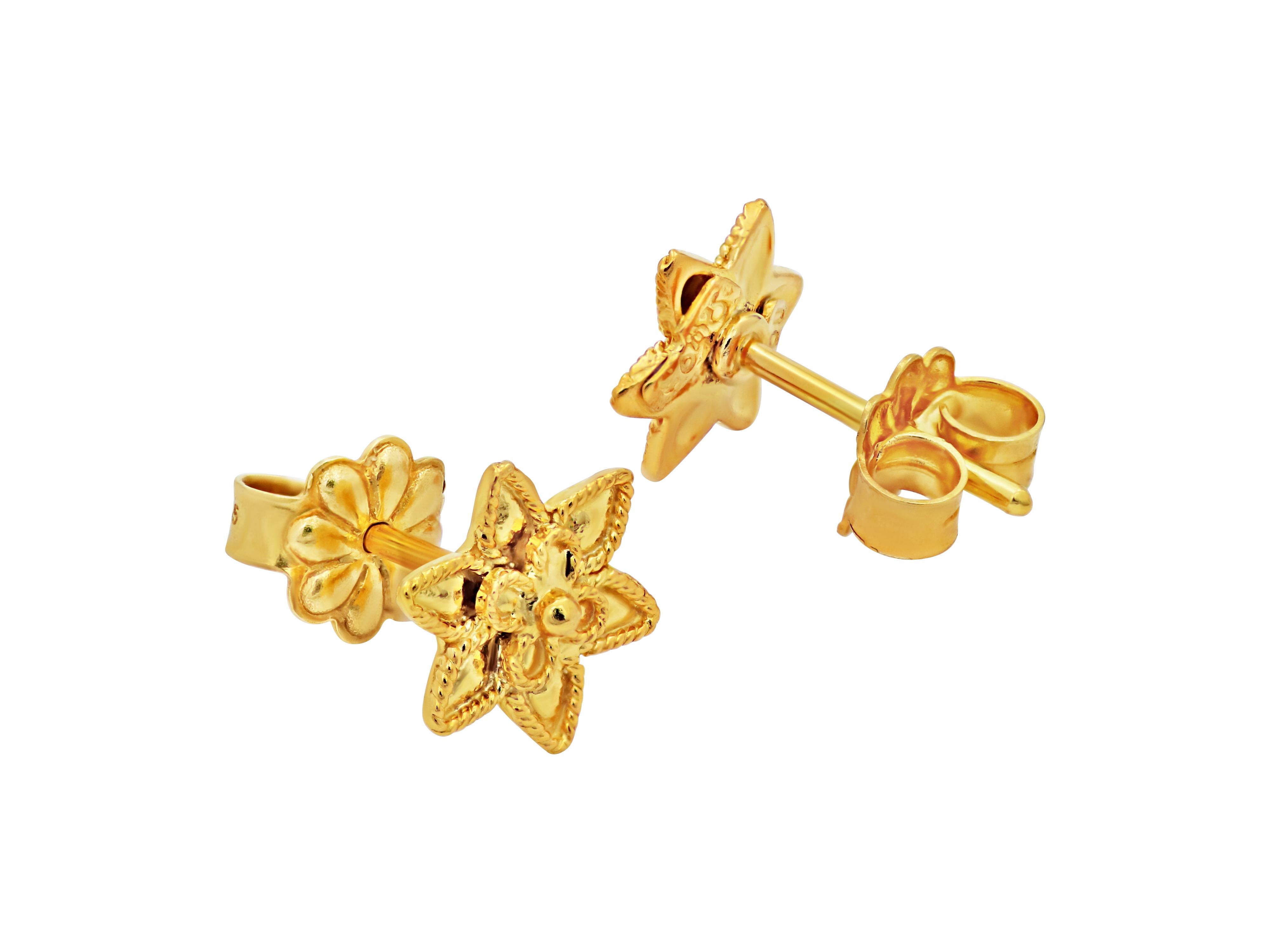 Star shape stud earrings in a small size with filigree design set with 18k yellow gold. Εach earring host a tiny daisy in the center. A neoclassical museum style work that shows class, taste and knowledge. 